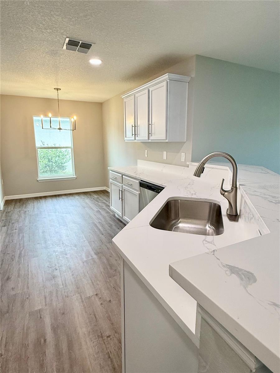 Spacious and modern kitchen features eat-in dining, newly installed quartz countertops, brand new stainless steel appliances, pantry and breakfast bar
