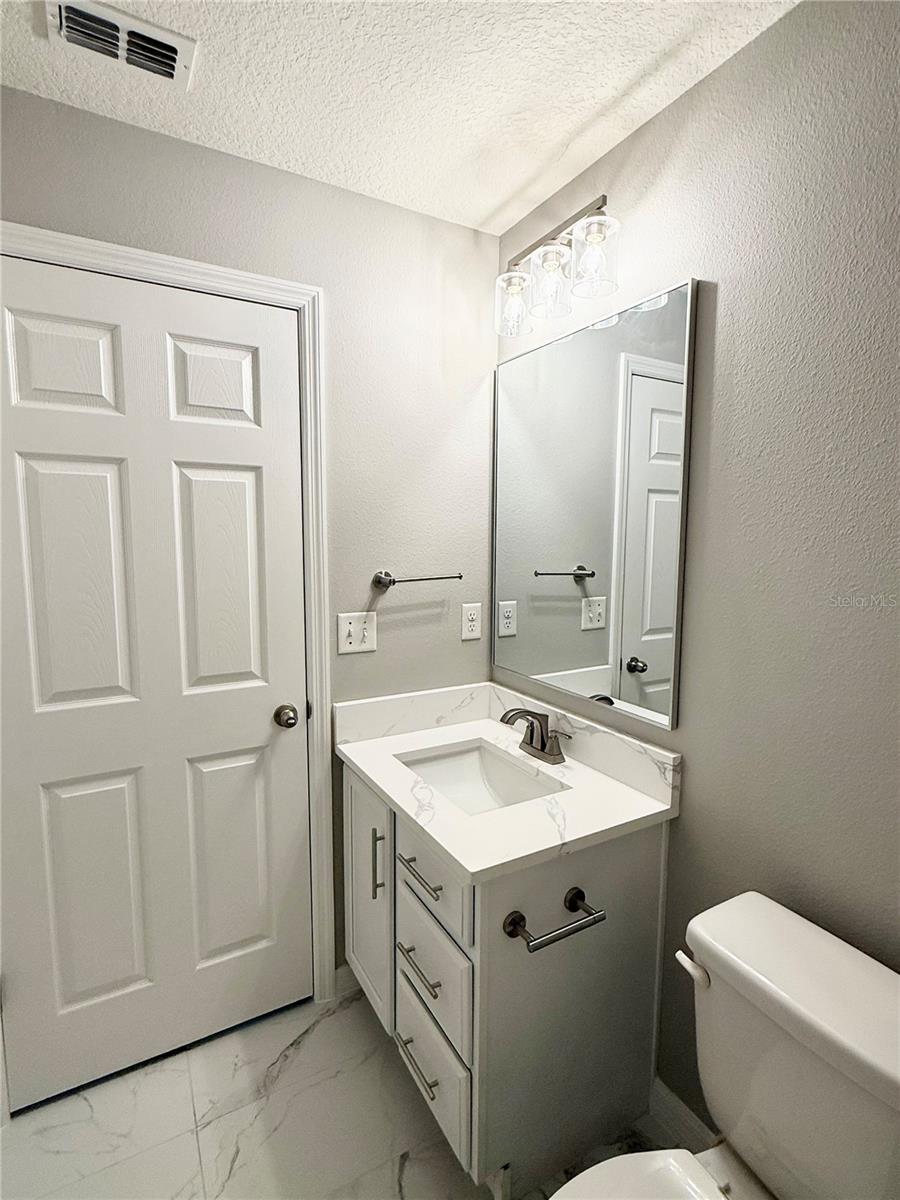Guest bathroom includes quartz vanity, new lighting and fixtures and newly installed marble design ceramic tile