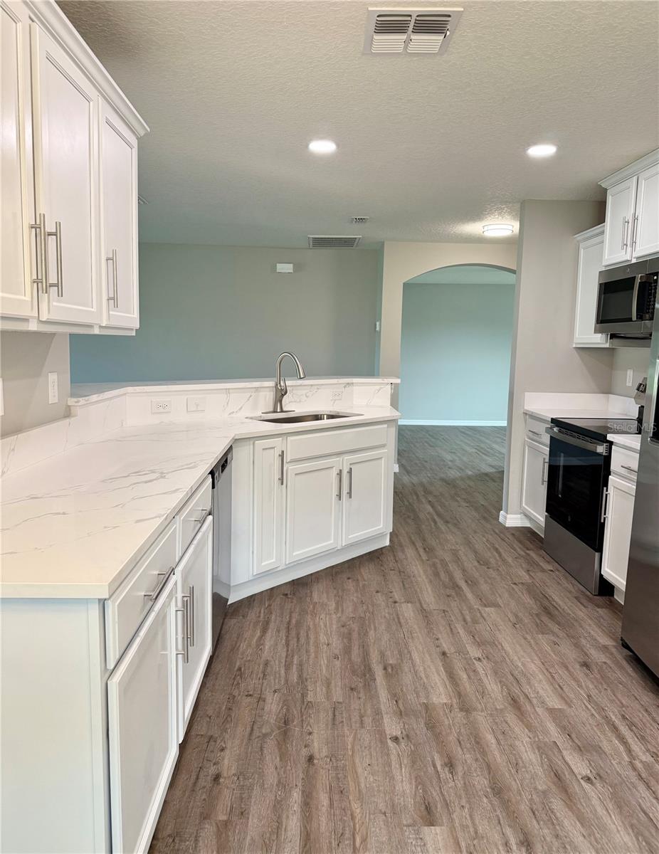 Spacious and modern kitchen features eat-in dining, newly installed quartz countertops, brand new stainless steel appliances, pantry and breakfast bar