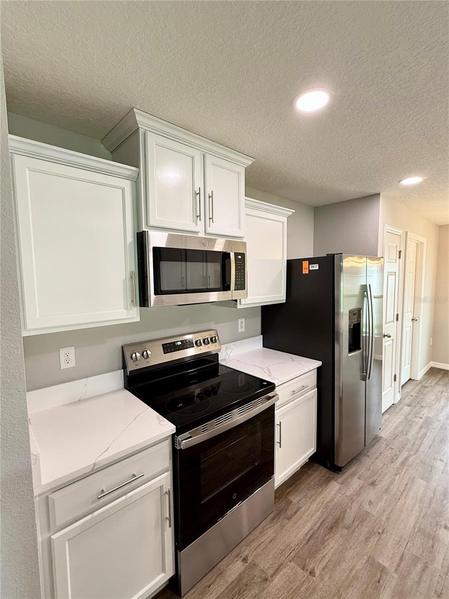 Spacious and modern kitchen features eat-in dining, newly installed quartz countertops, brand new stainless steel appliances, pantry and breakfast bar