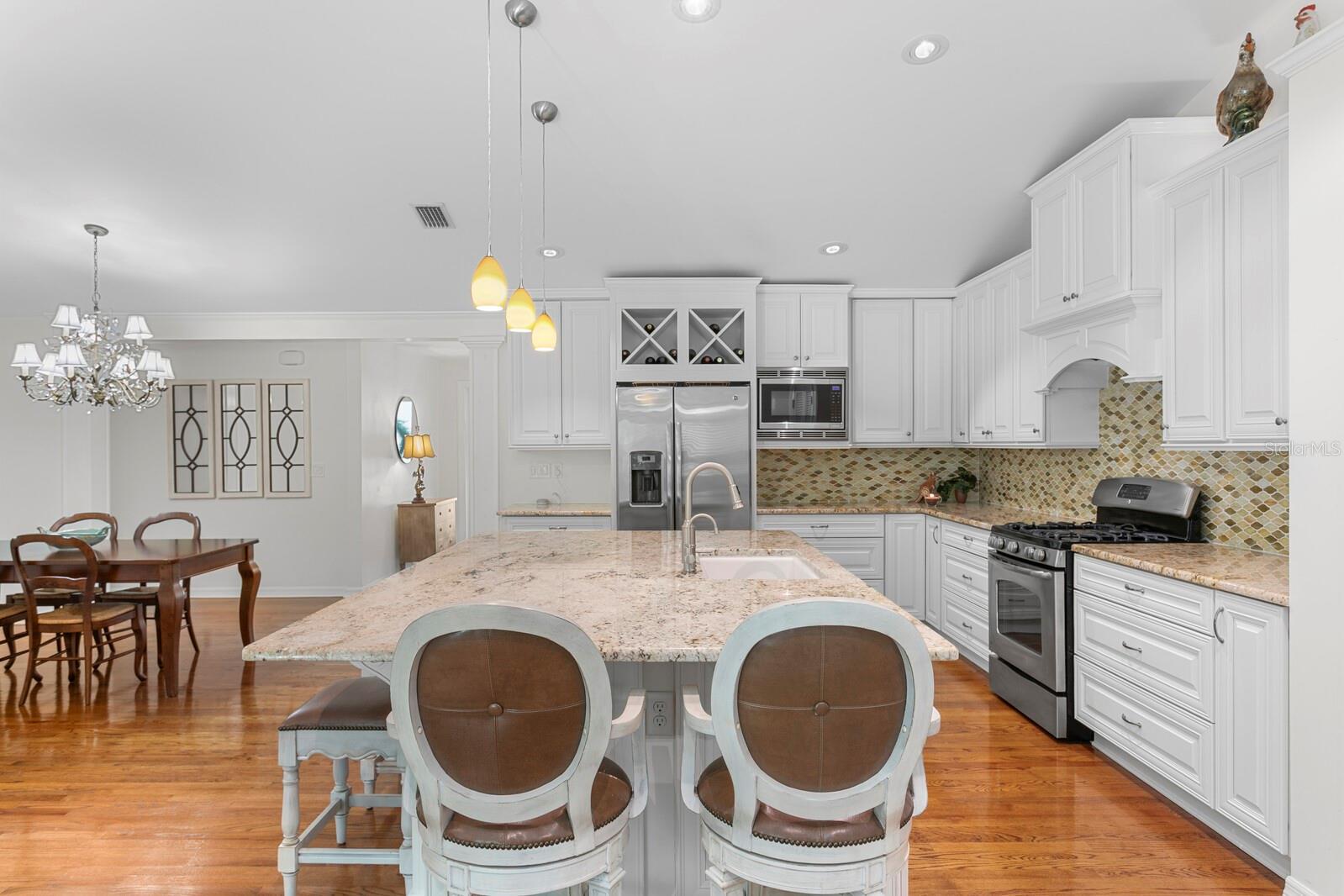 Standing at the back of kitchen, looking toward the dining room to your left and front door beyond.