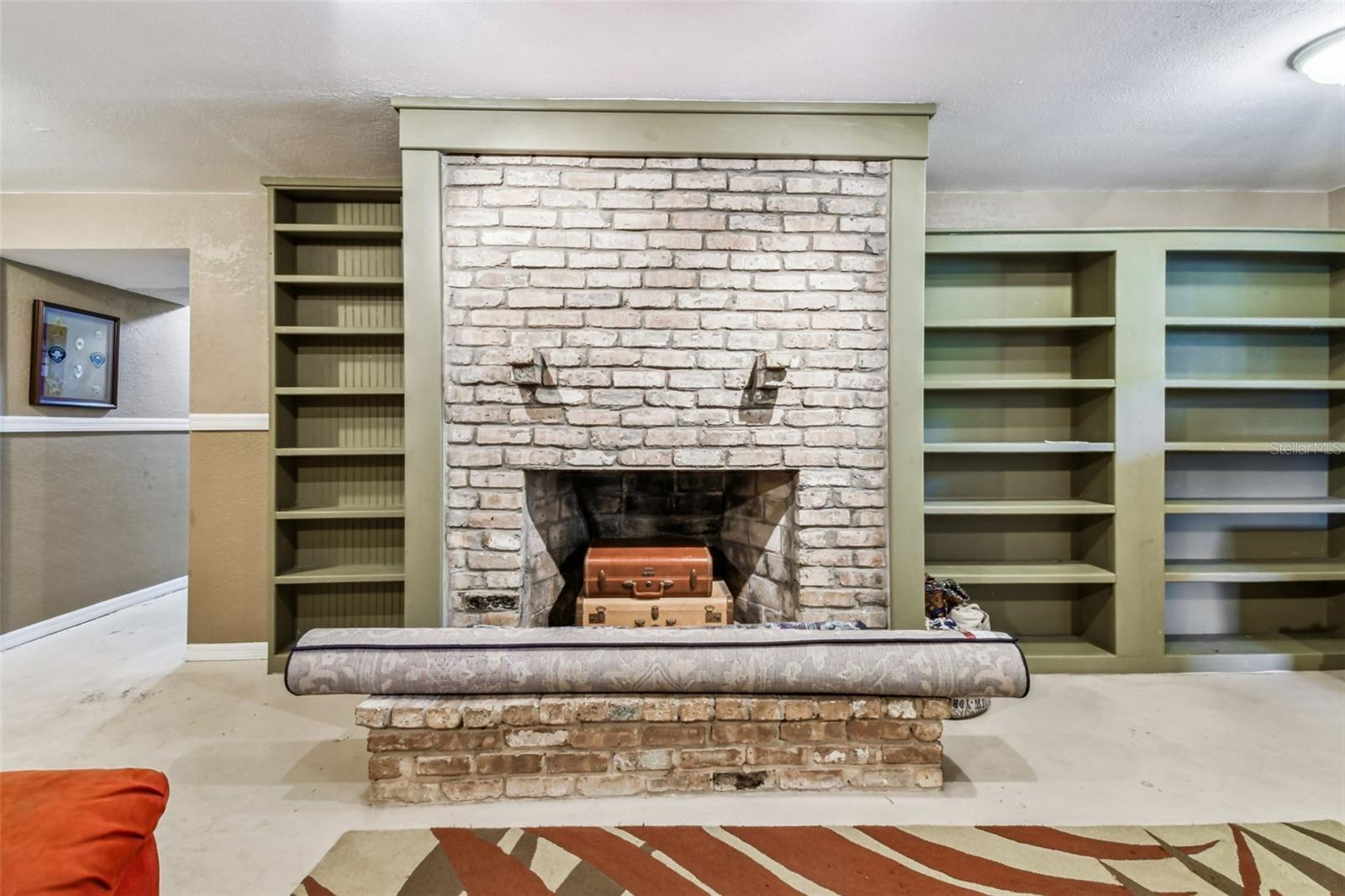 Basement family room with built ins and wood burning fireplace