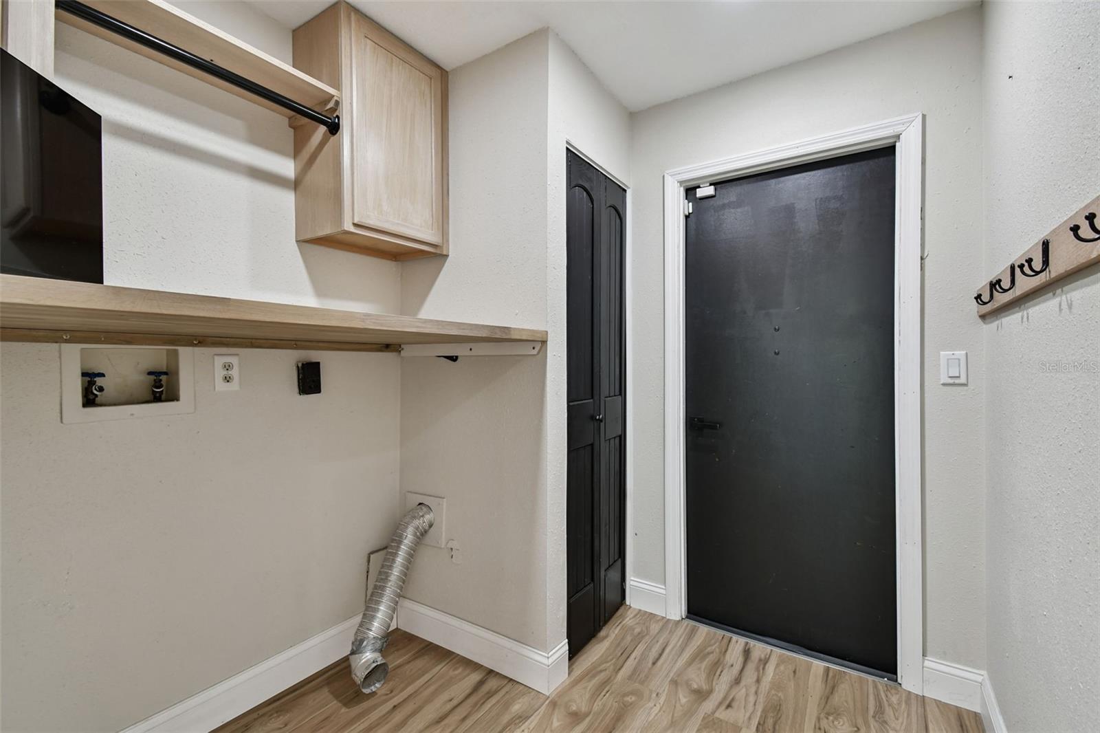 Laundry Room with Cabinets, shelving and a closet