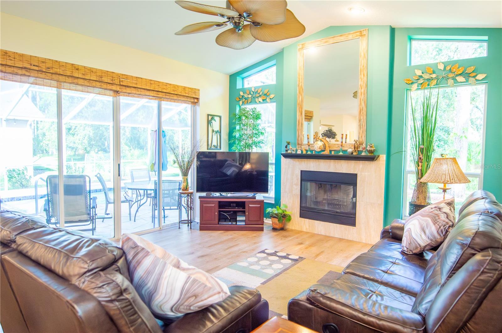 Wood-burning fireplace with mirror on mantle. Windows view the birds in the natural backyard oasis.