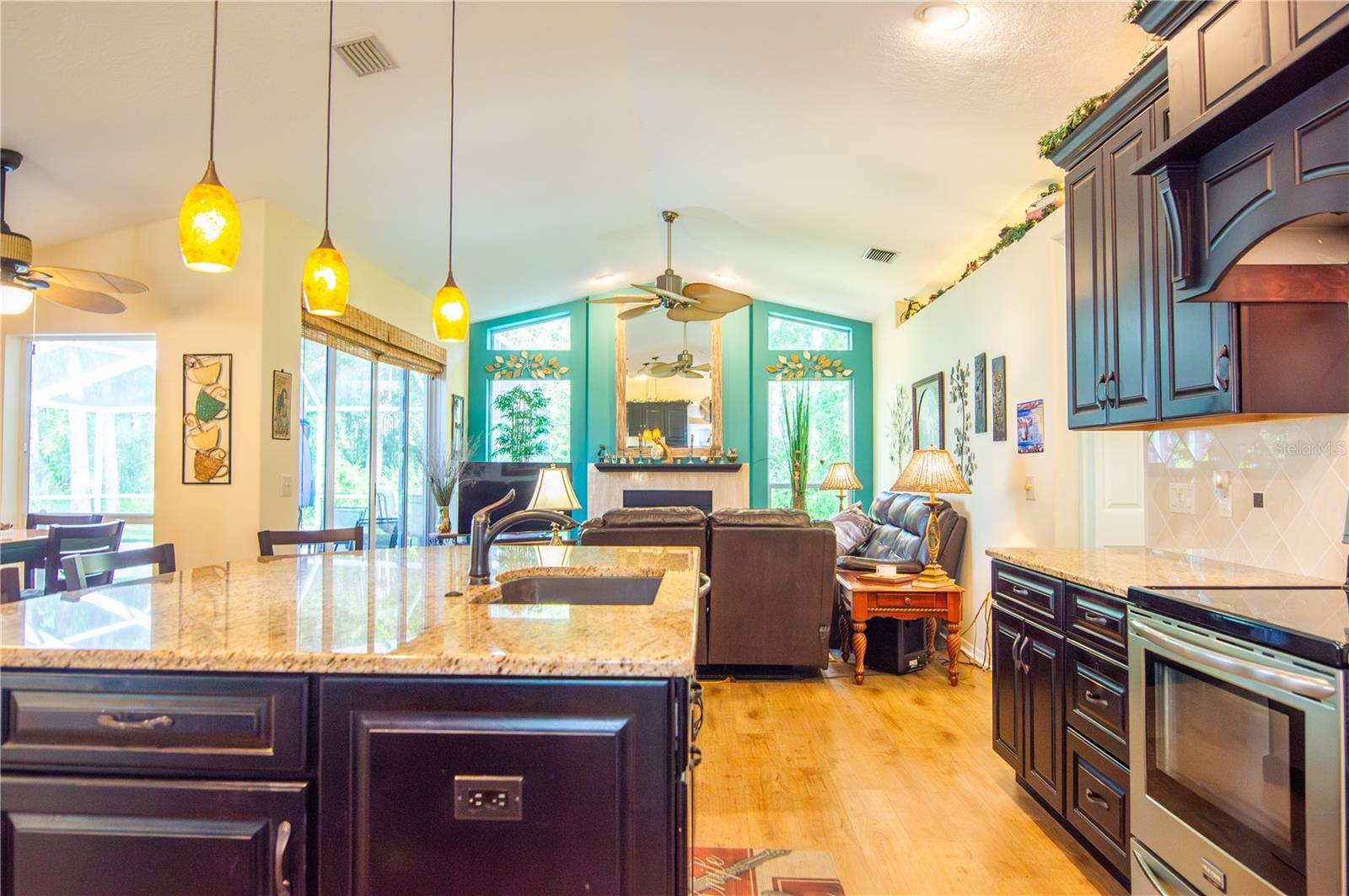 Kitchen opens to the Family Room with pool views.