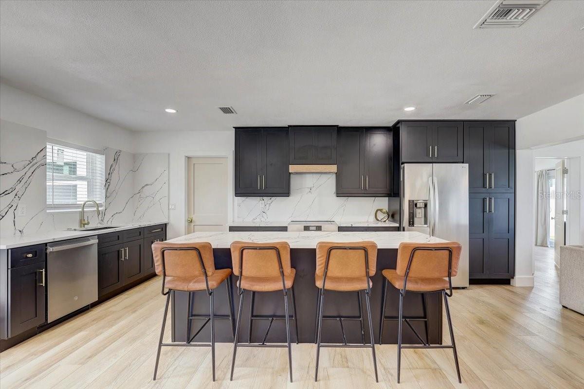 Island has drawers and cabinets, built-in microwave, trash can holder and spice rack