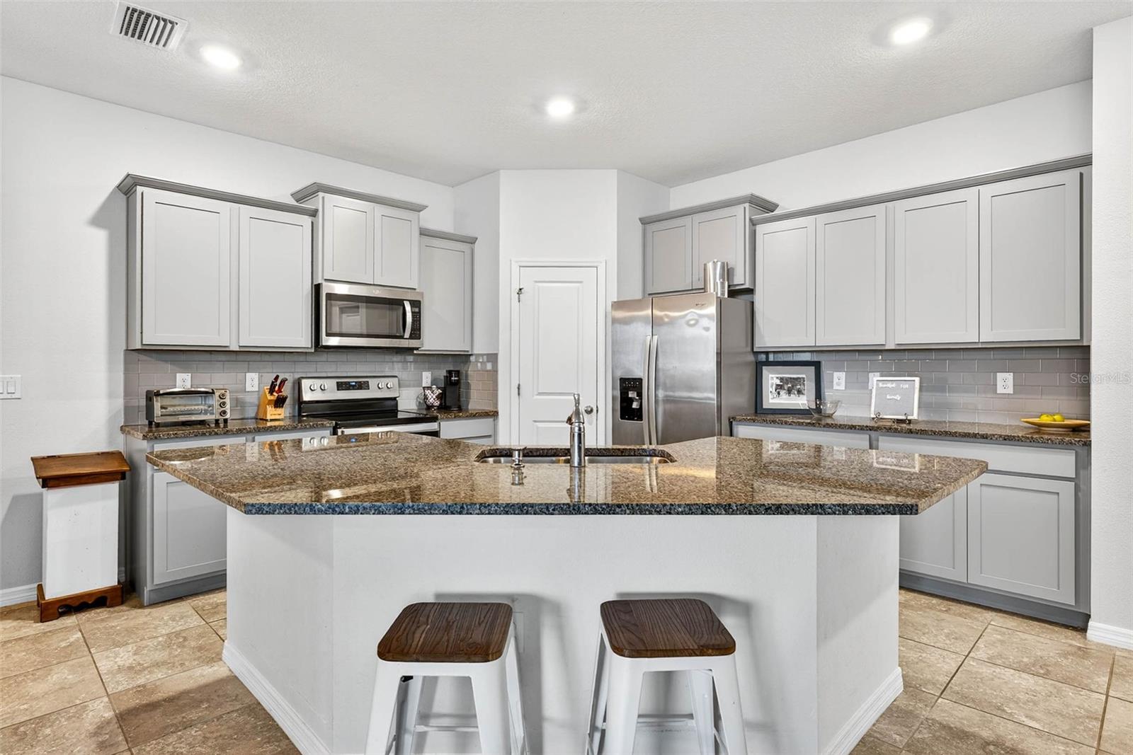 Kitchen has granite countertops, 42" shaker cabinetry, closet pantry and stainless steel appliances.