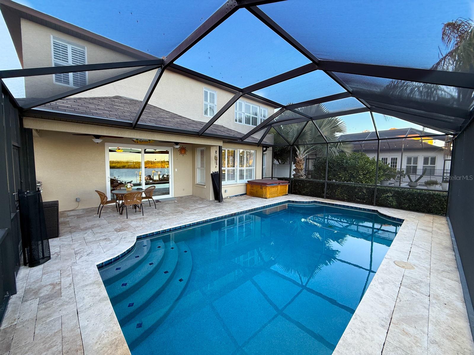 pool and lanai with upgraded travertine stone decking