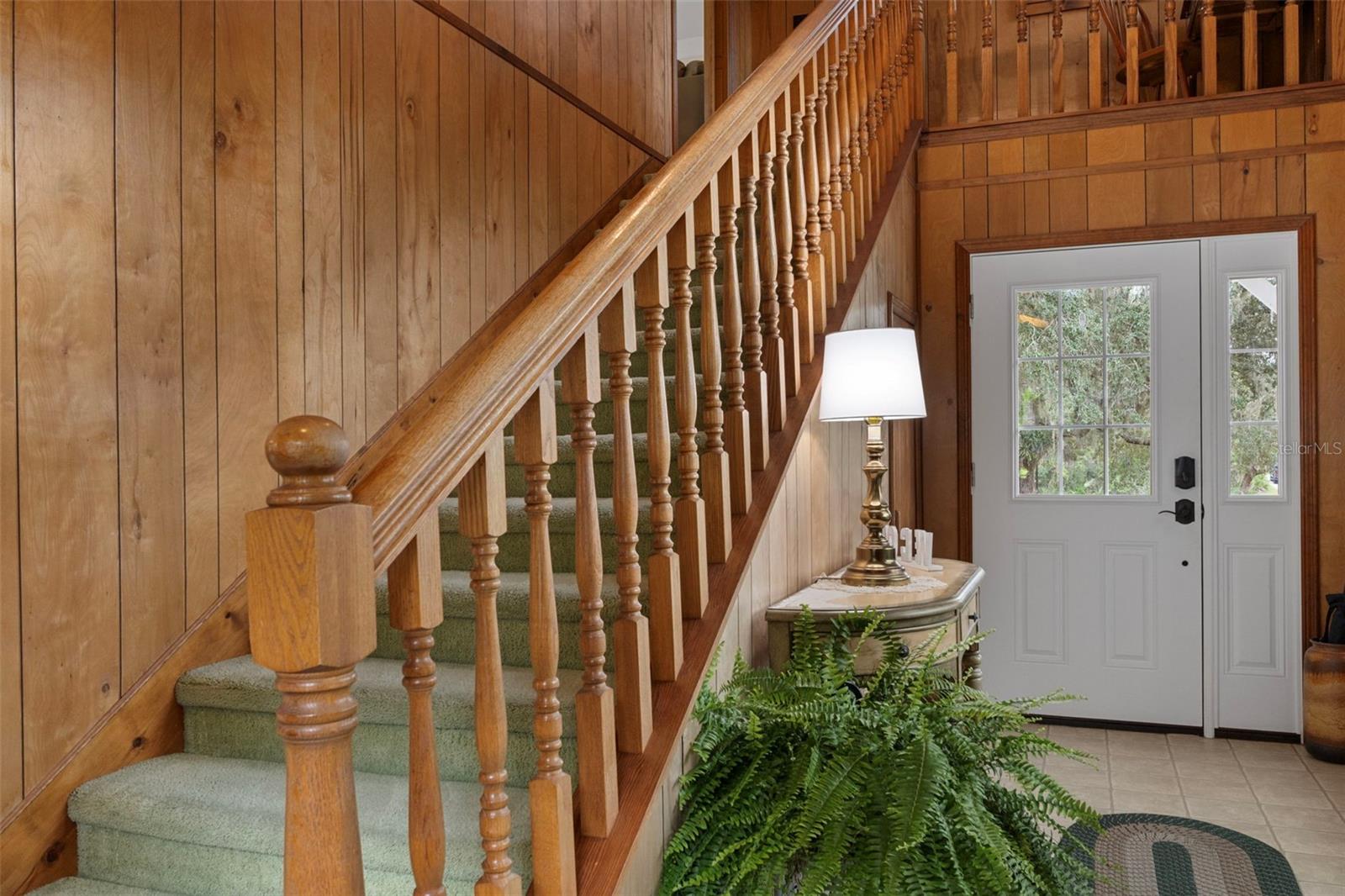 Wide staircase leads to full kitchen, dining, living, 2 bedrooms and balcony