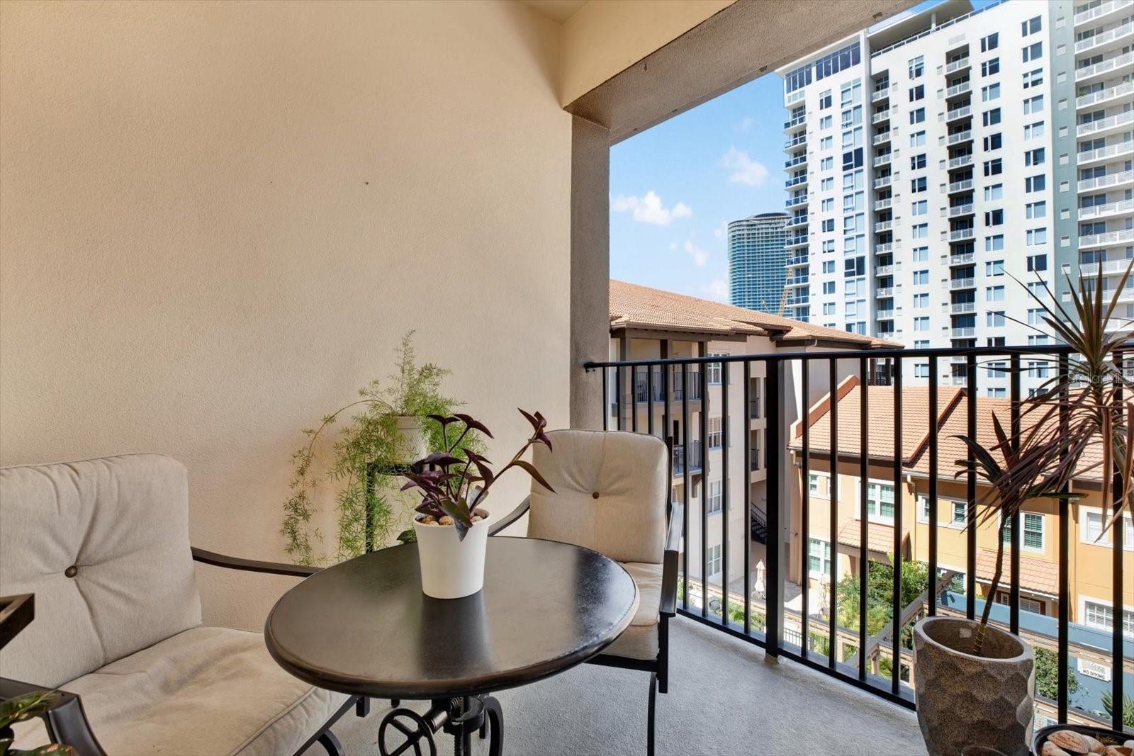 Private balcony overlooking courtyard and city skyline