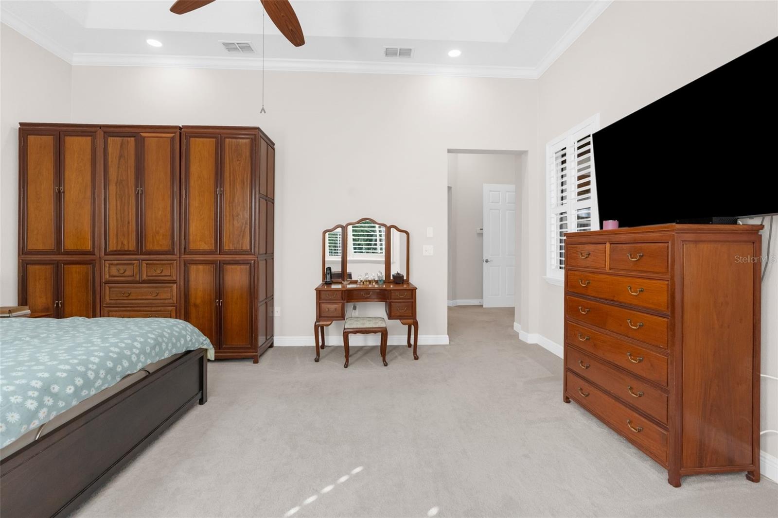 Master suite: Large bedroom with bay window and tray ceiling.
