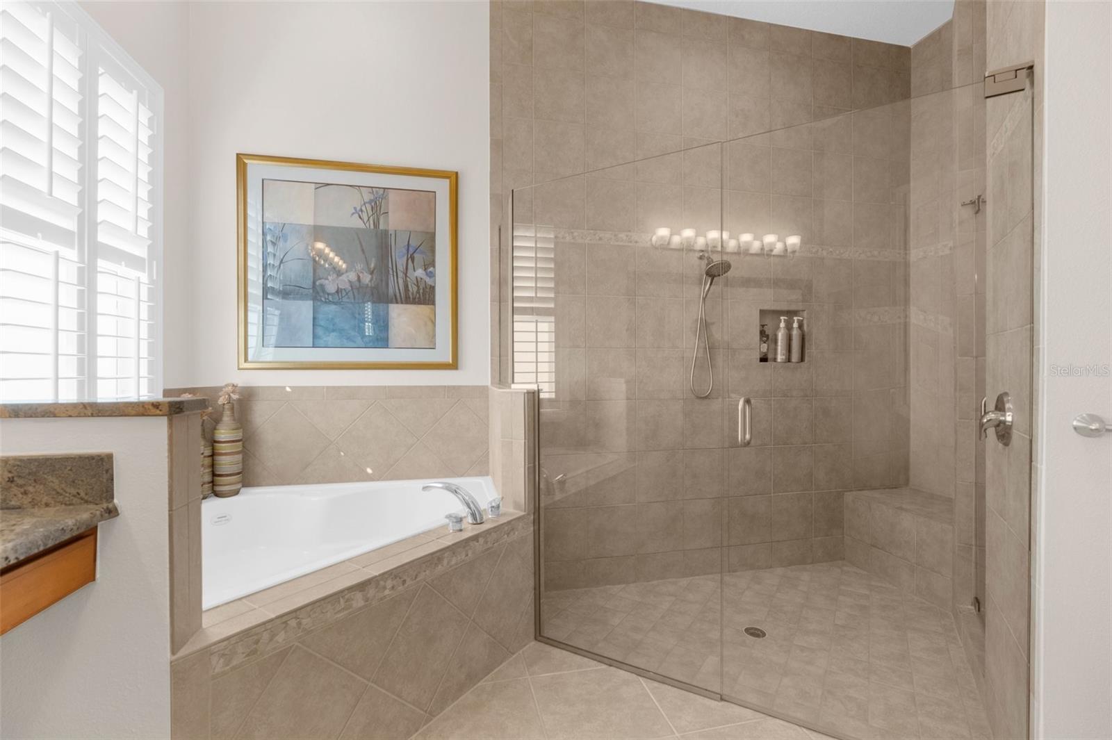 Master suite: "Her" bath area with huge shower, frameless glass enclosure and floor to ceiling tiles.