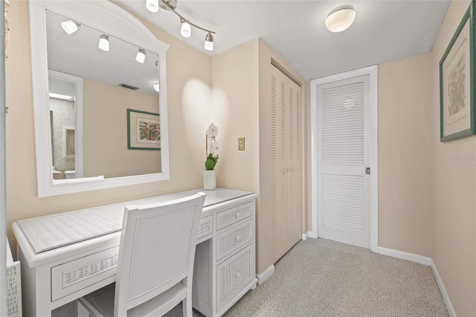 Vanity area and large walk in closet behind the closed doors.