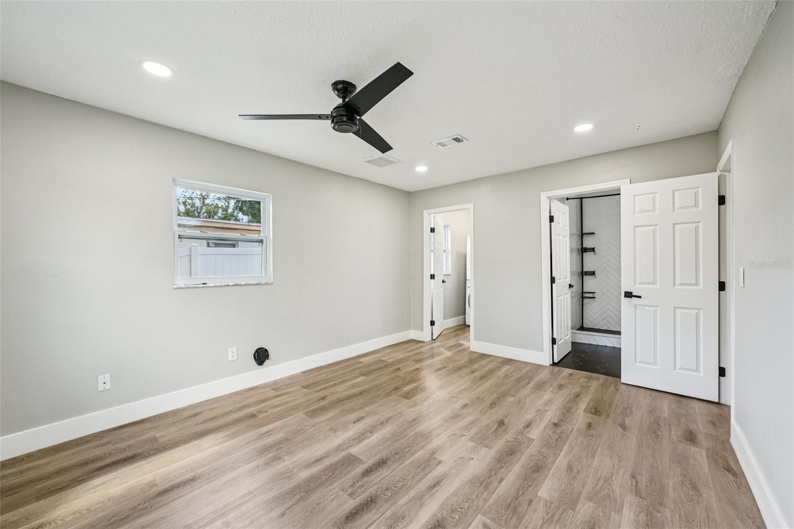 The primary bedroom offers generous space, recessed lighting, a walk-in closet, and an ensuite bathroom. Both bathrooms feature modern finishes, including a sleek vanity with an LED mirror, and a gleaming tiled shower with contemporary accents.