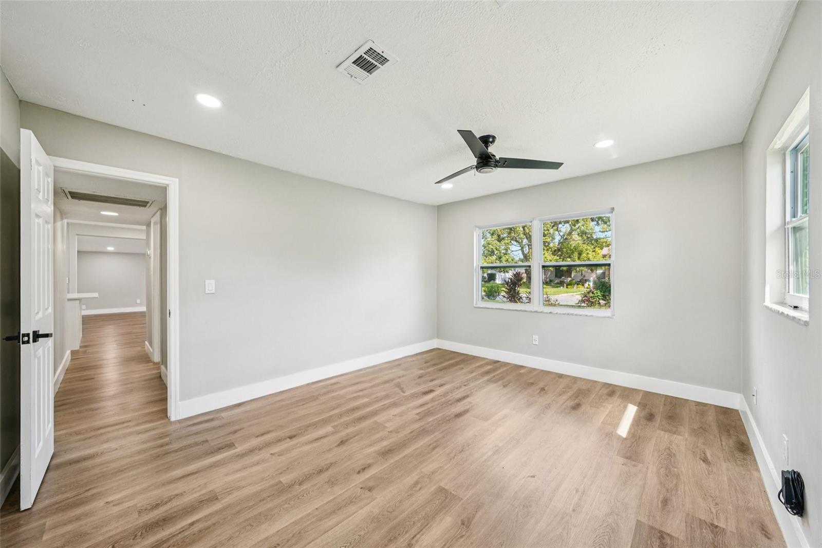 The primary bedroom offers generous space, recessed lighting, a walk-in closet, and an ensuite bathroom. Both bathrooms feature modern finishes, including a sleek vanity with an LED mirror, and a gleaming tiled shower with contemporary accents.