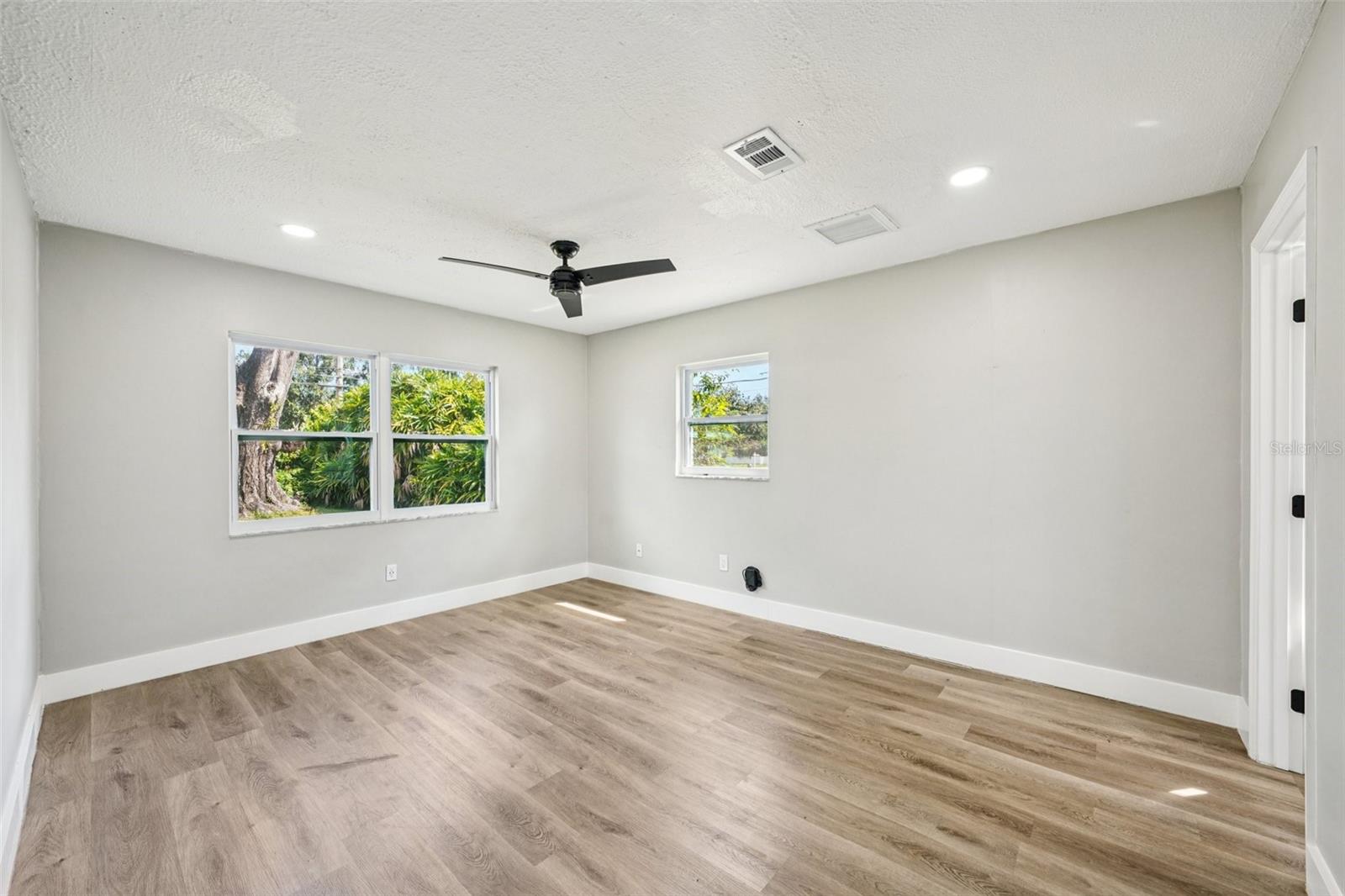 The primary bedroom offers generous space, recessed lighting, a walk-in closet, and an ensuite bathroom. Both bathrooms feature modern finishes, including a sleek vanity with an LED mirror, and a gleaming tiled shower with contemporary accents.