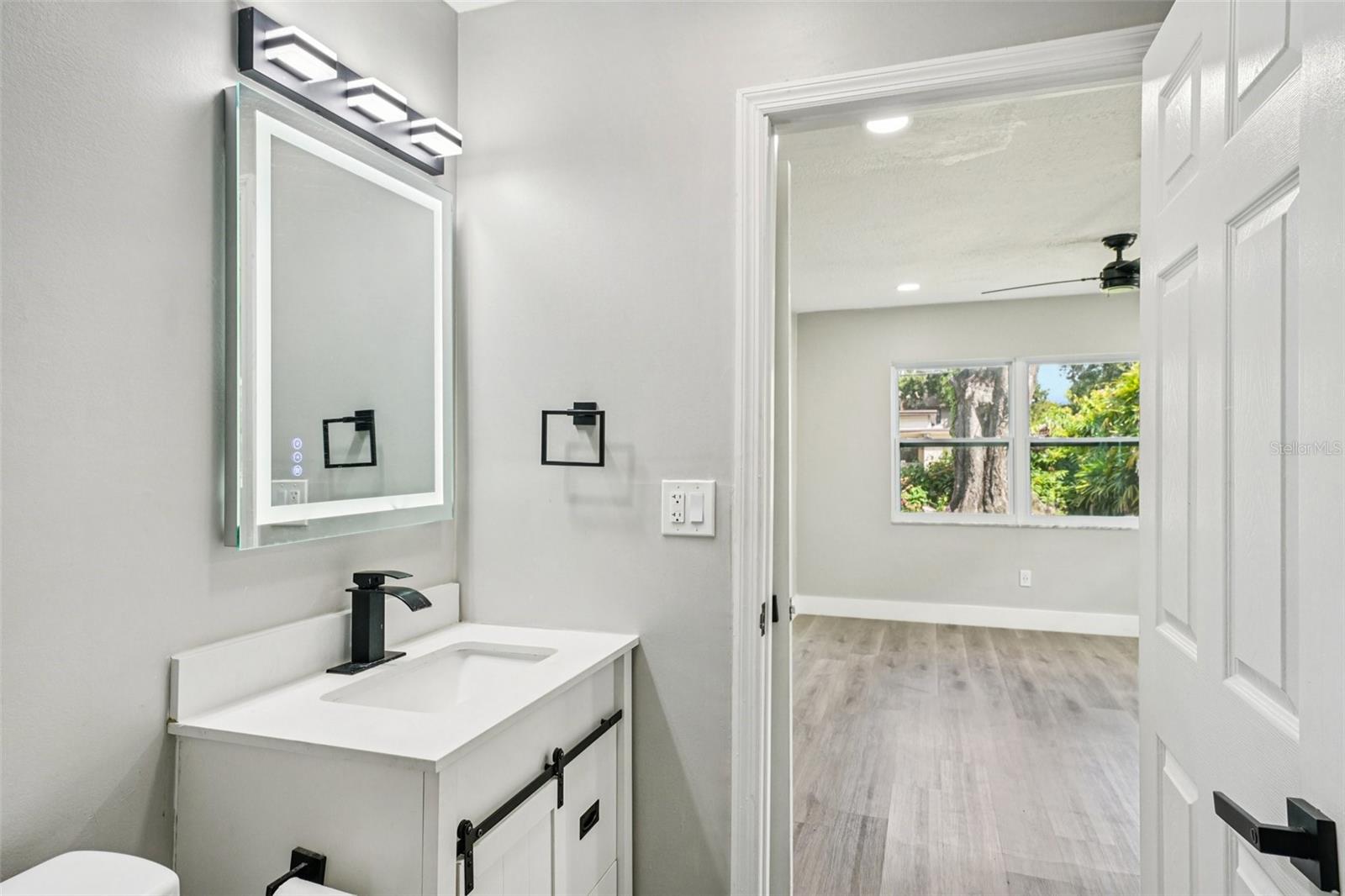 Primary ensuite bathroom features modern finishes, including a sleek vanity with an LED mirror, and a gleaming tiled shower with contemporary accents