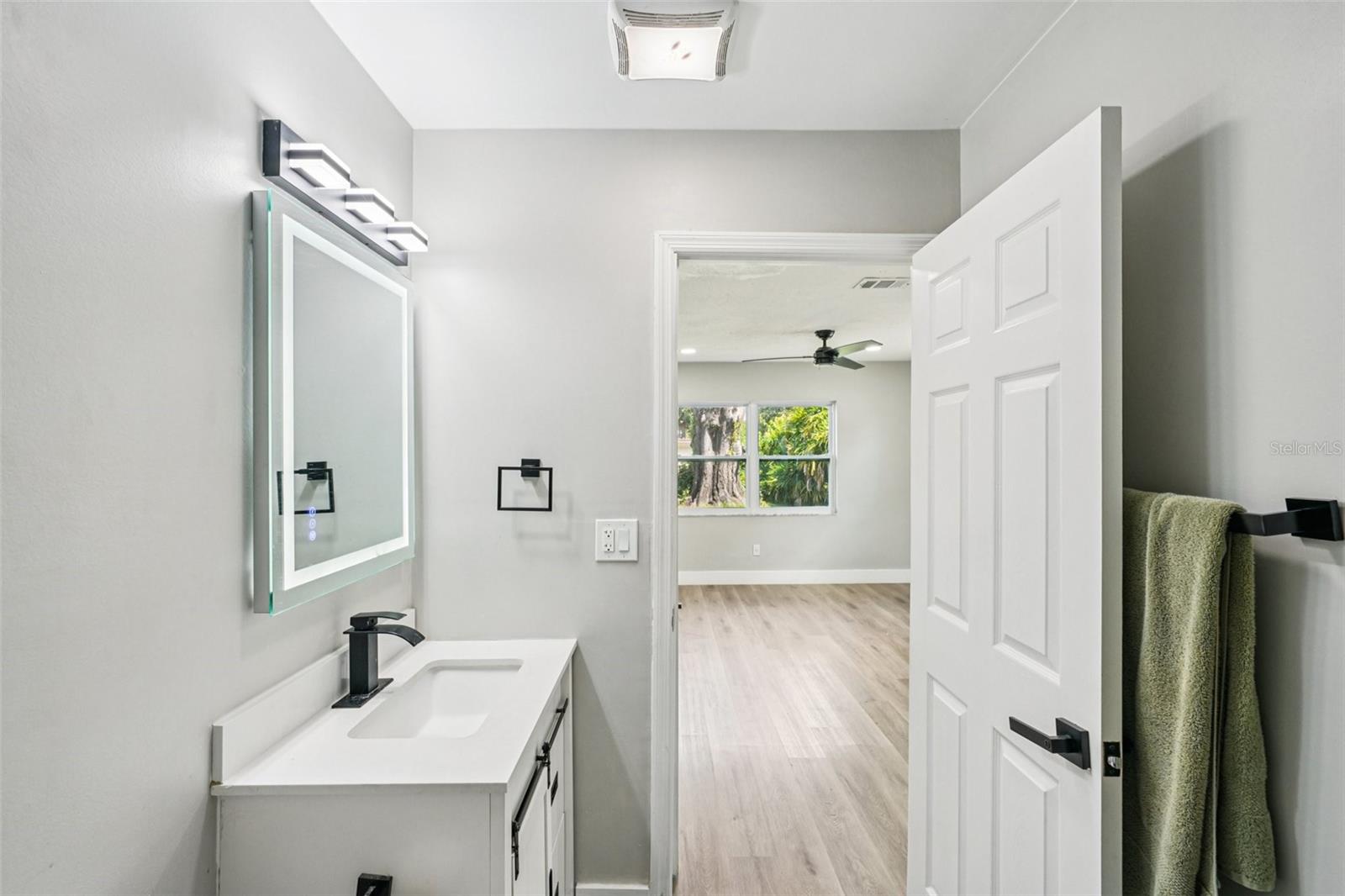 Primary ensuite bathroom features modern finishes, including a sleek vanity with an LED mirror, and a gleaming tiled shower with contemporary accents