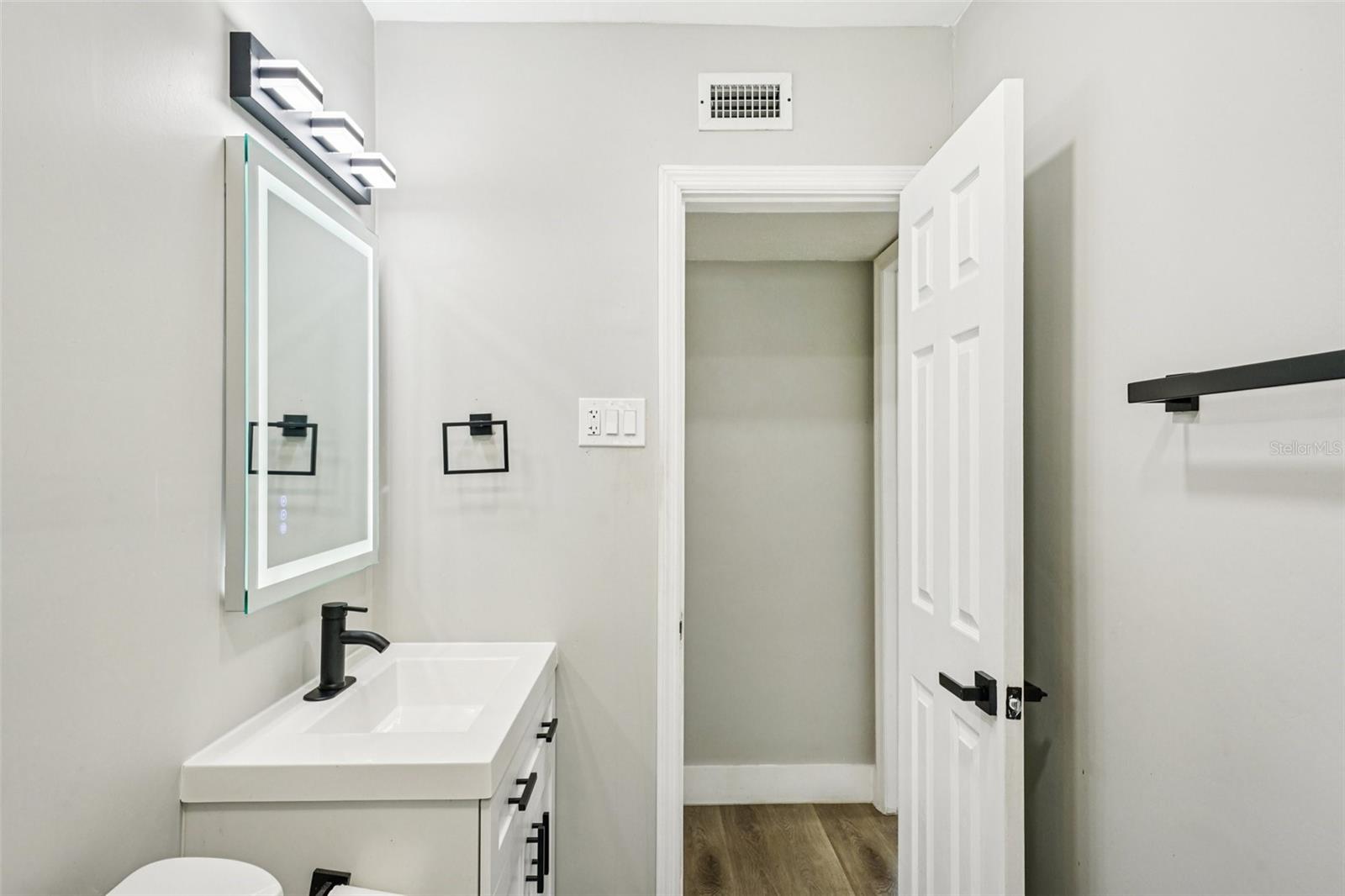 Second Bathroom features modern finishes, including a sleek vanity with an LED mirror, and a gleaming tiled shower with contemporary accents