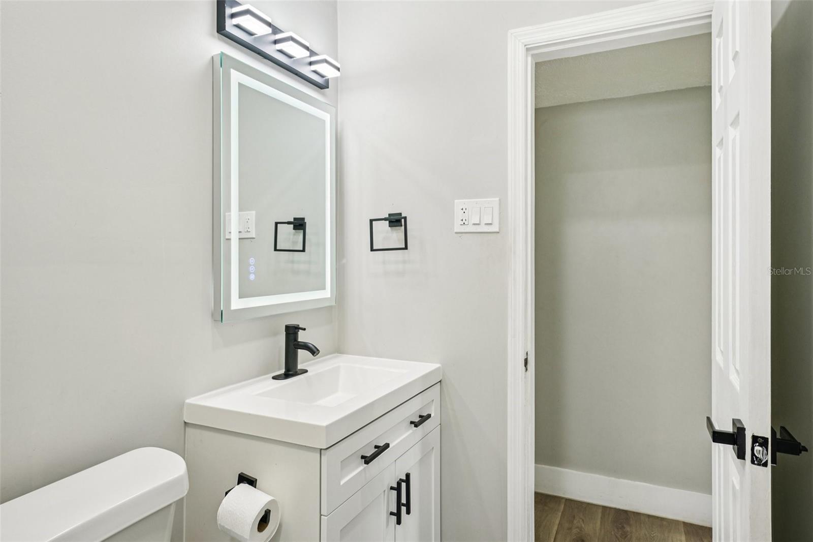 Second Bathroom features modern finishes, including a sleek vanity with an LED mirror, and a gleaming tiled shower with contemporary accents
