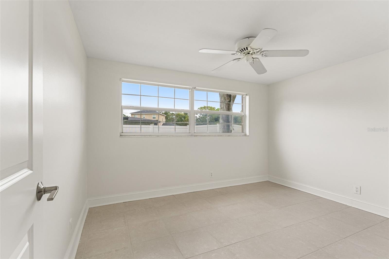 Additional bedroom with wide windows and neutral tones—ideal for guests, a study, or creative space.