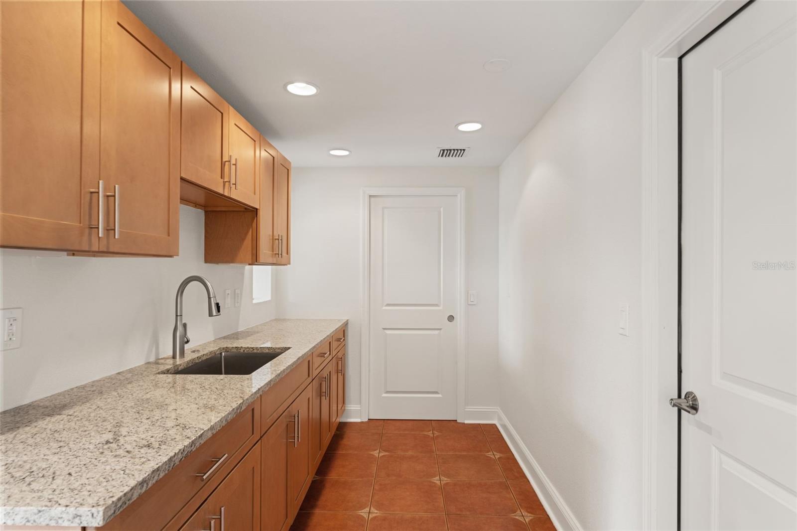 Long granite counters and a second sink provide added prep space, ideal for entertaining or everyday cooking.