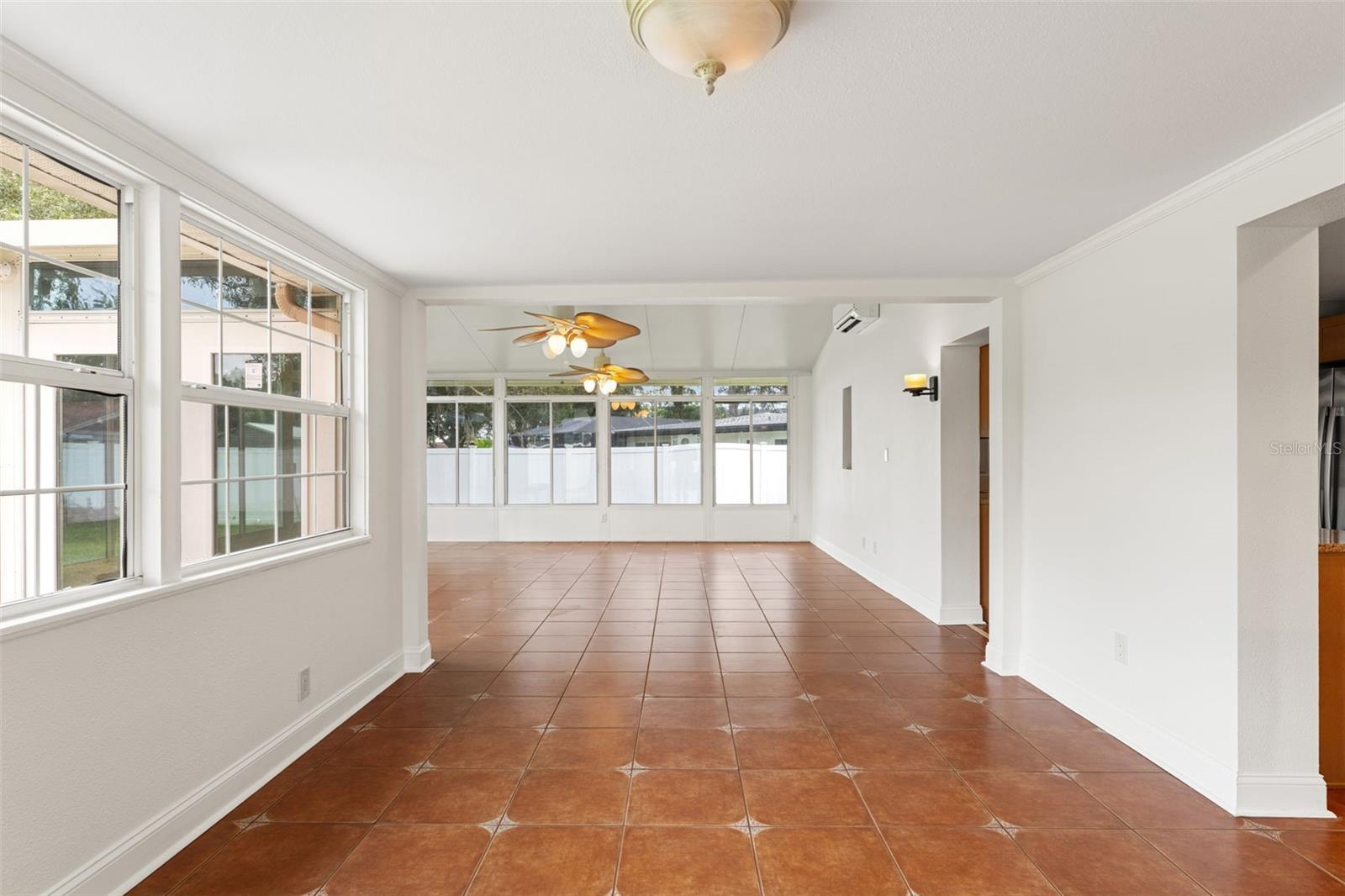 Sunlit dining space with oversized windows overlooking the backyard, creating a bright and cheerful atmosphere