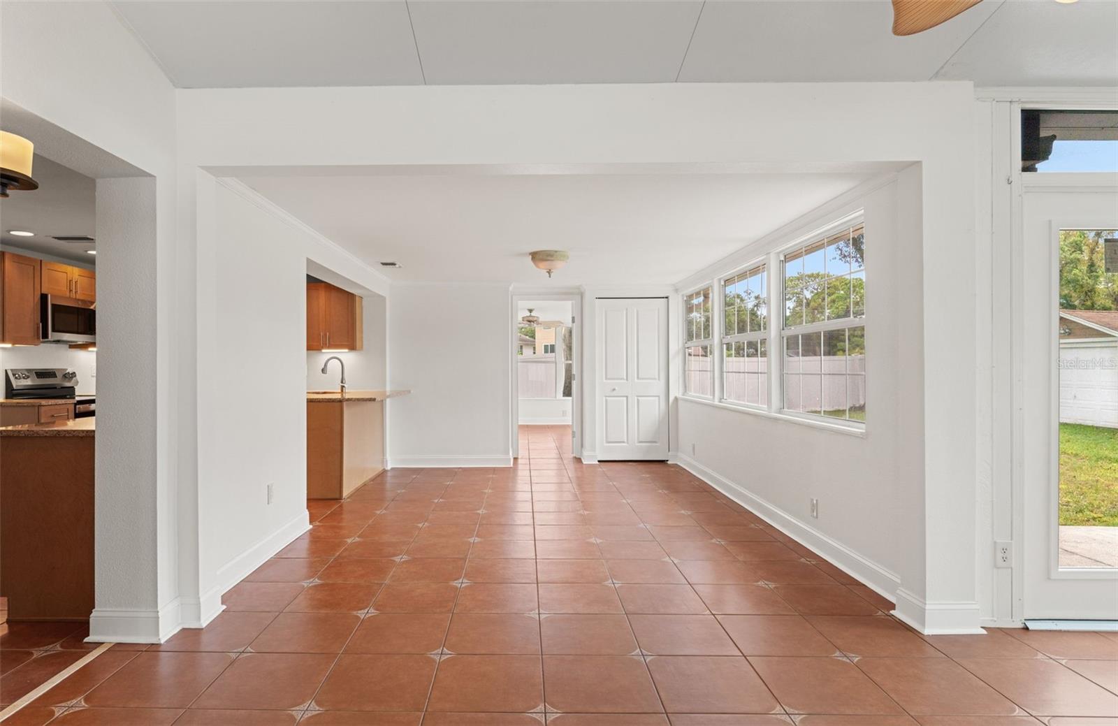 A light-filled transition area uniting the kitchen, dining, and sunroom zones for easy flow throughout the home.