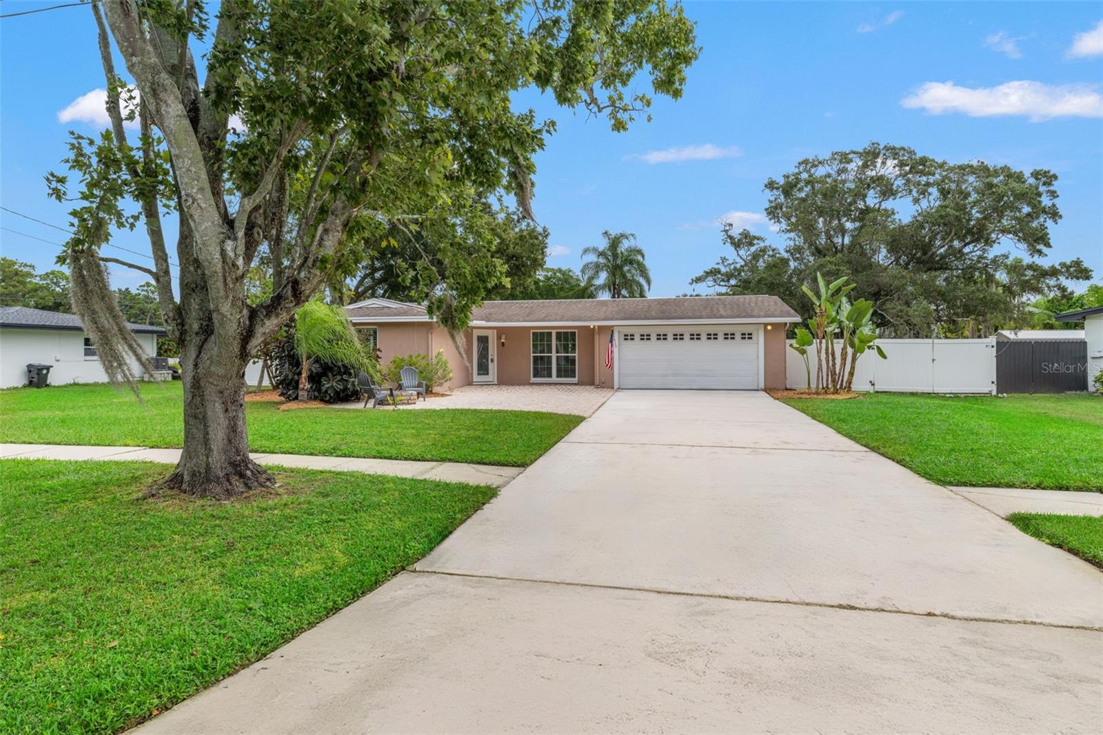 Situated on a quiet, tree-lined street, this home offers excellent curb presence with a clean façade and tropical foliage.