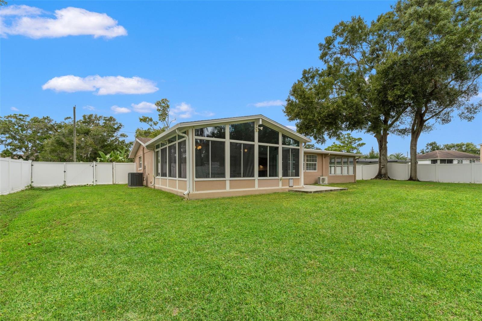 Peaceful and private outdoor retreat surrounded by a vinyl fence and lush greenery.