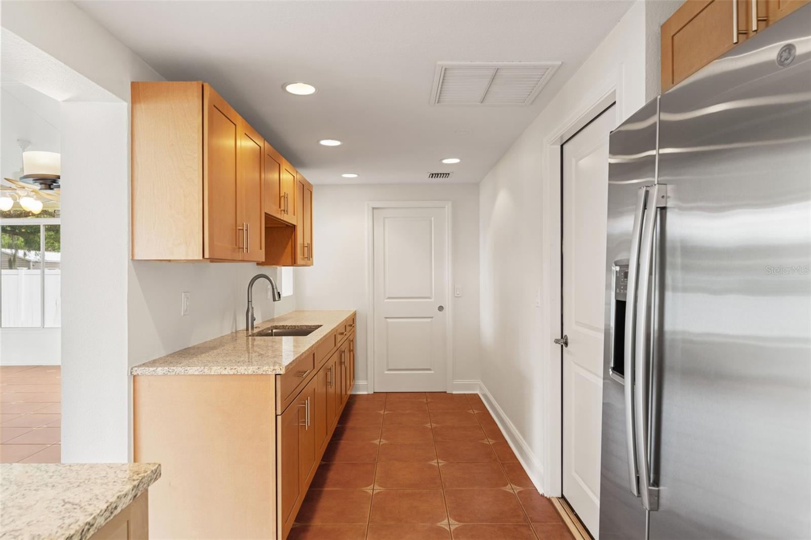 Bright and open with under-cabinet lighting, recessed fixtures, and a seamless transition to the dining and sunroom areas.