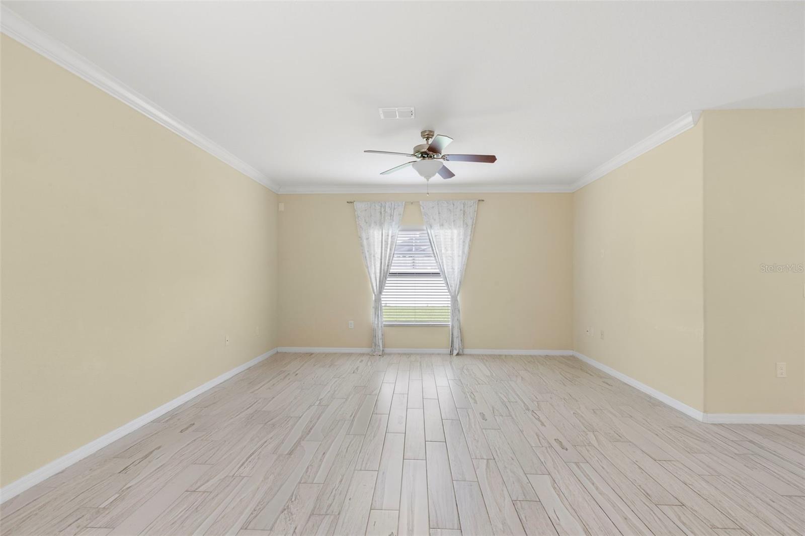 Living Room with crown molding and ceiling fan