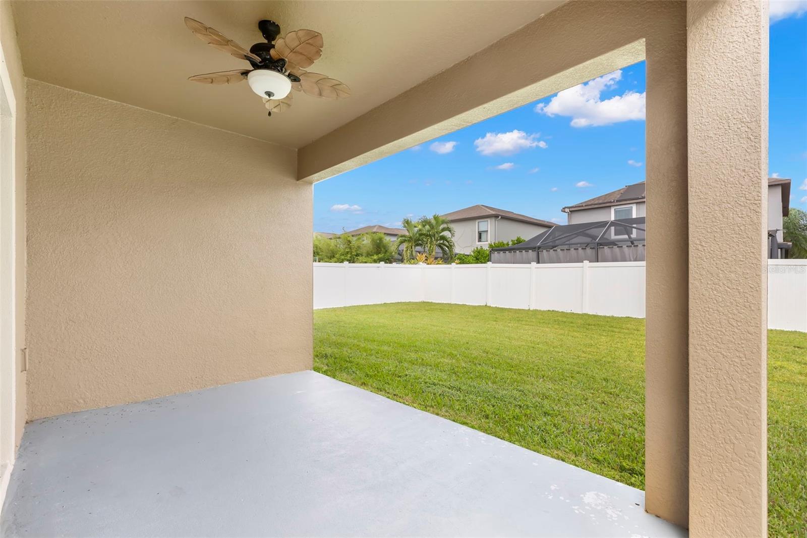 Covered lanai in back with tropical ceiling fan and outlet