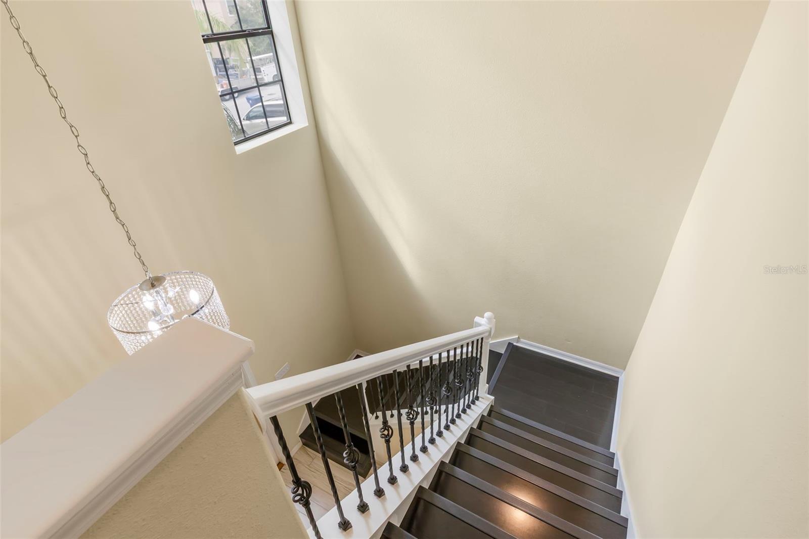 Grand staircase with wrought iron spindles and laminate wood steps