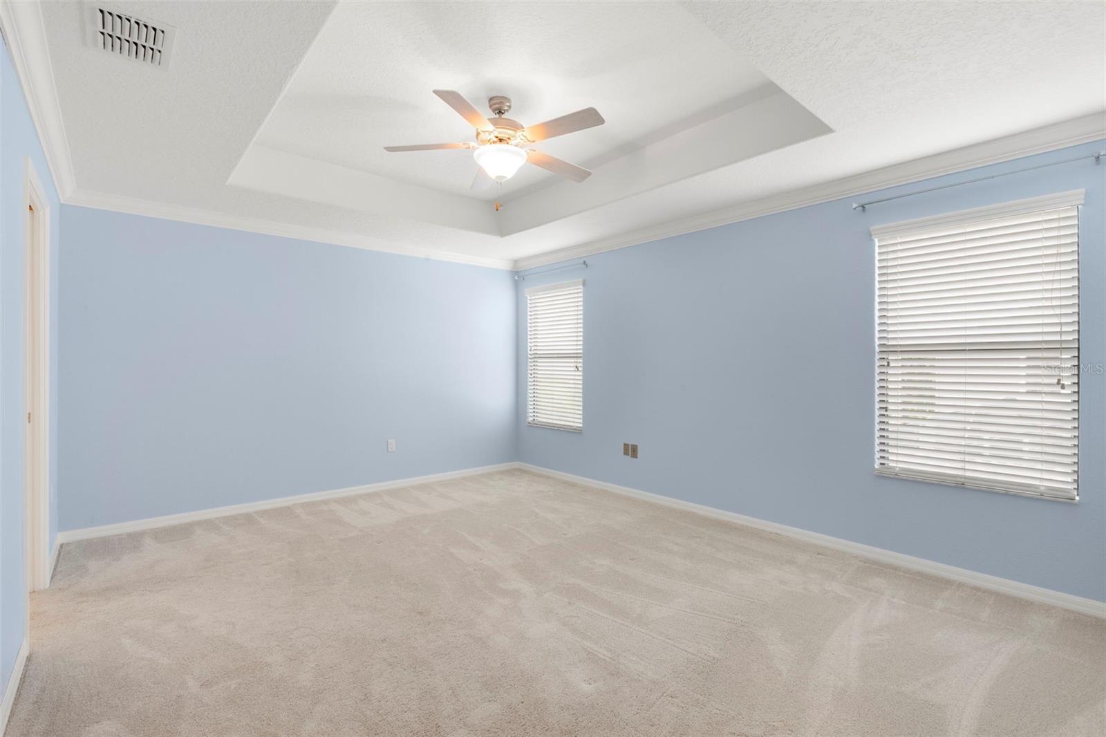 Primary Bedroom Suite with crown molding, tray ceilings, large walk-in closet and En Suite bathroom.