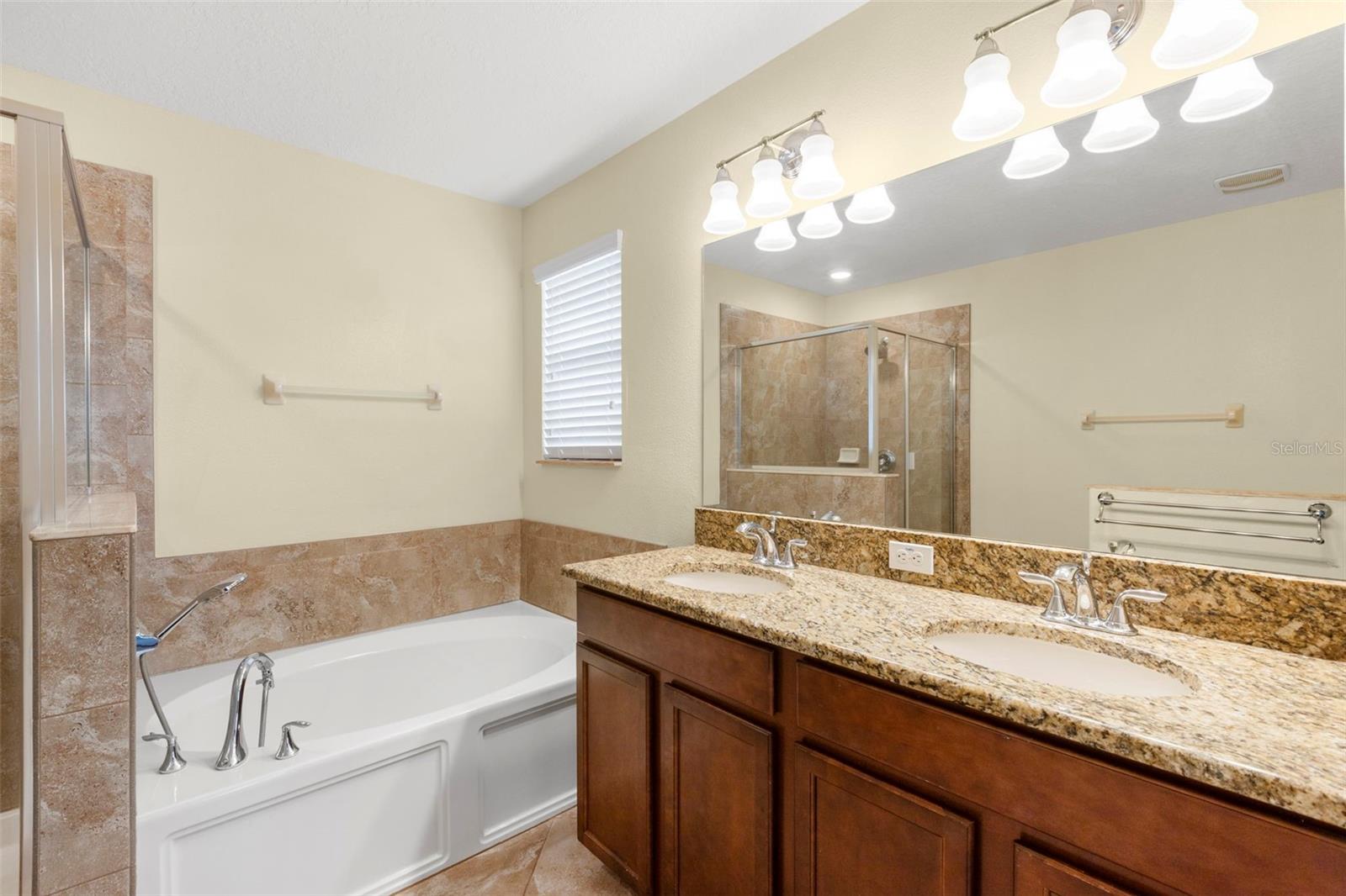 Primary En Suite Bathroom with dual sinks, granite counters, garden tub and separate shower.