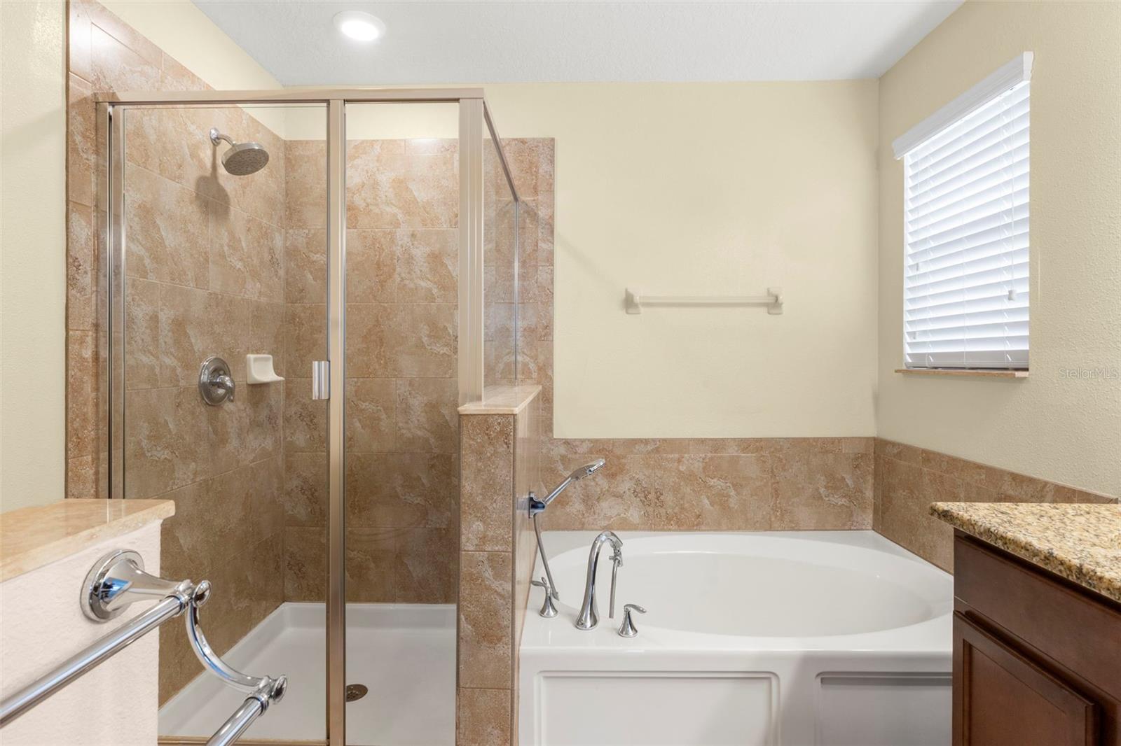 Primary En Suite Bathroom with dual sinks, granite counters, garden tub and separate shower.