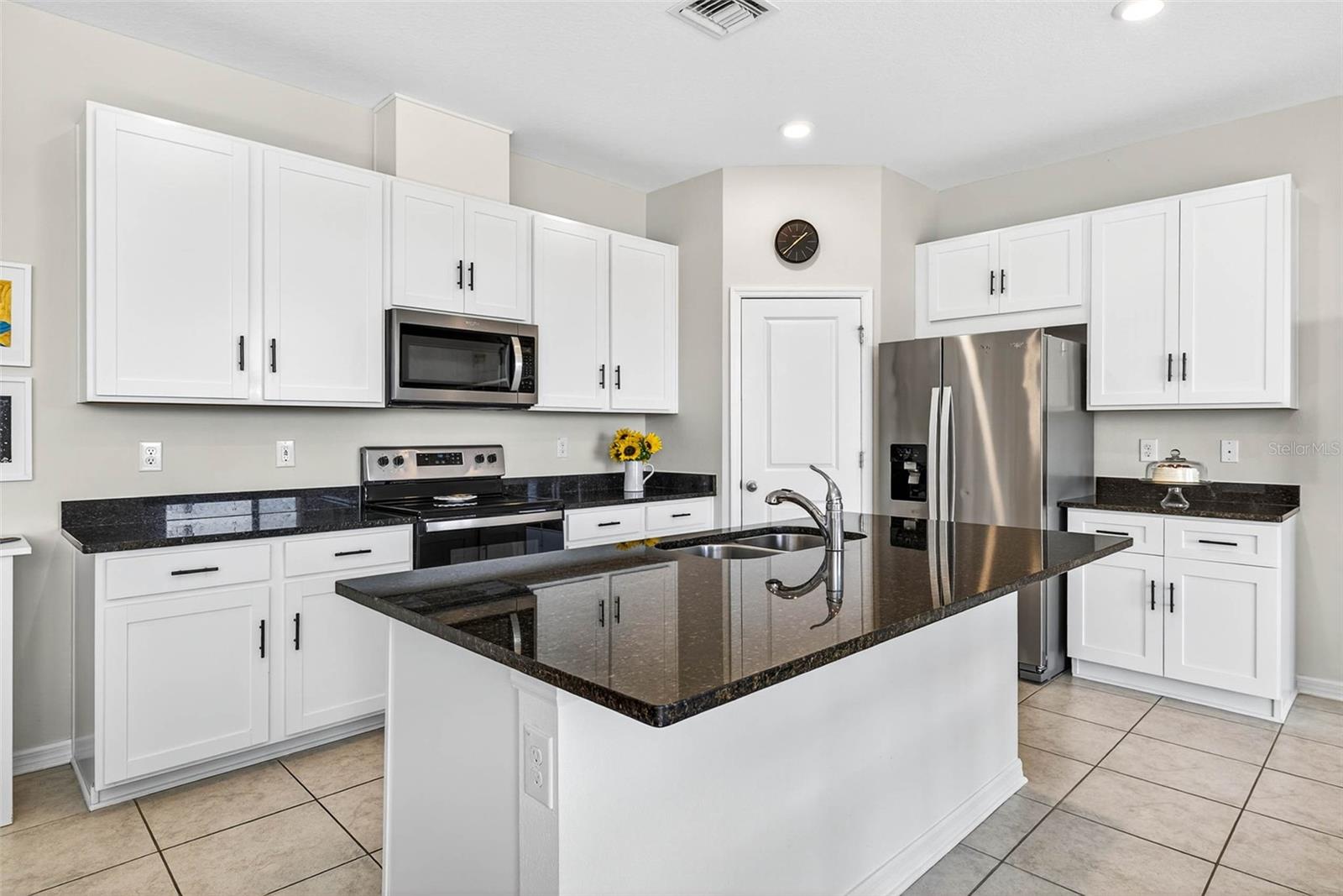 Black quartz countertops, white shaker cabinetry & closet pantry- stainless steel appliance package.