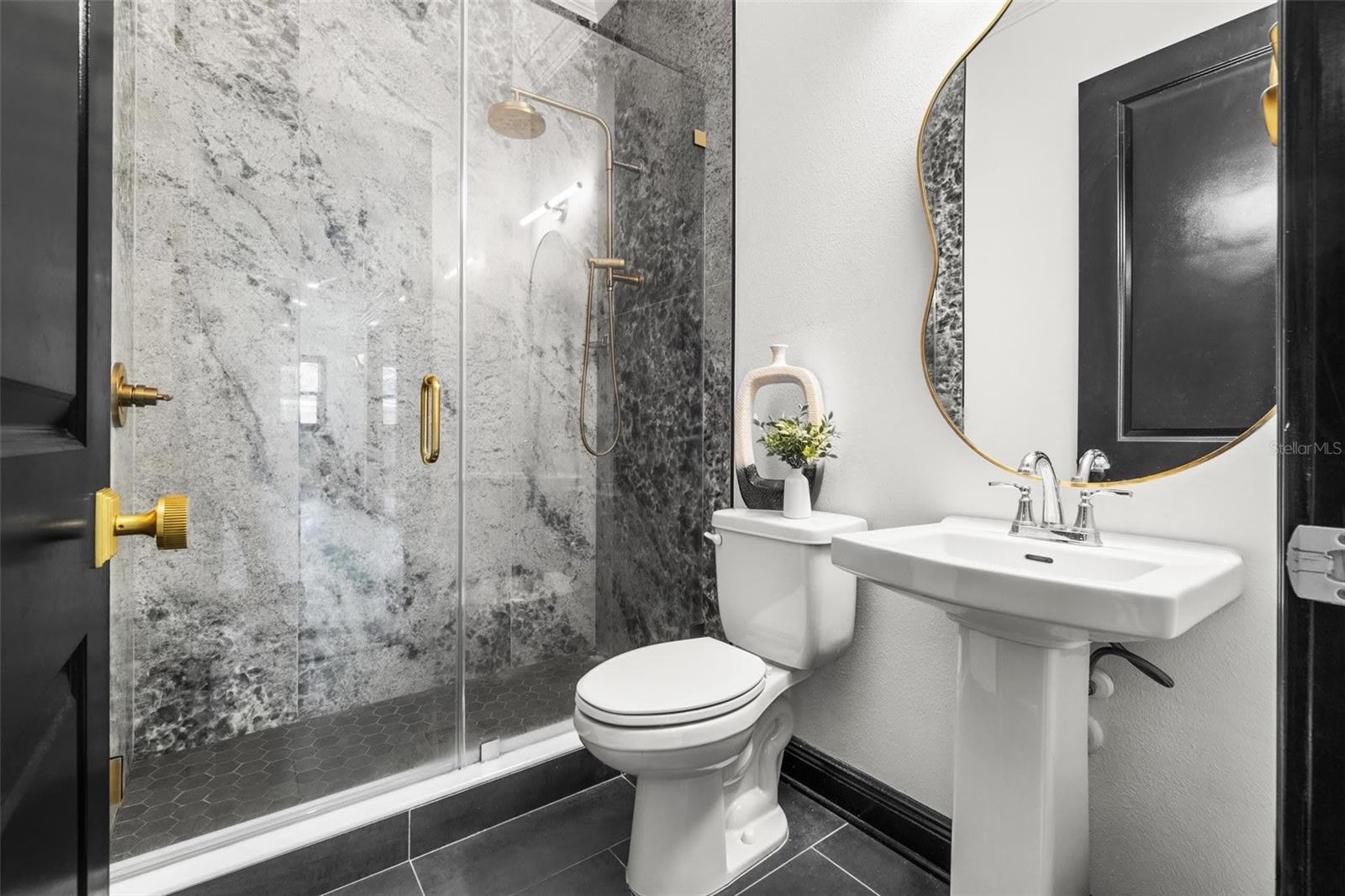 Large floor to ceiling porcelain slab shower w glass enclosure.