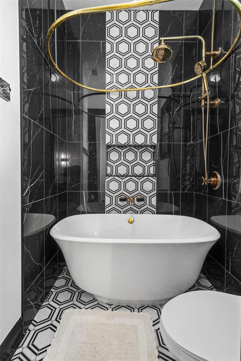 Bathroom 3 Tub/Shower Combo with Marble Accent Wall.