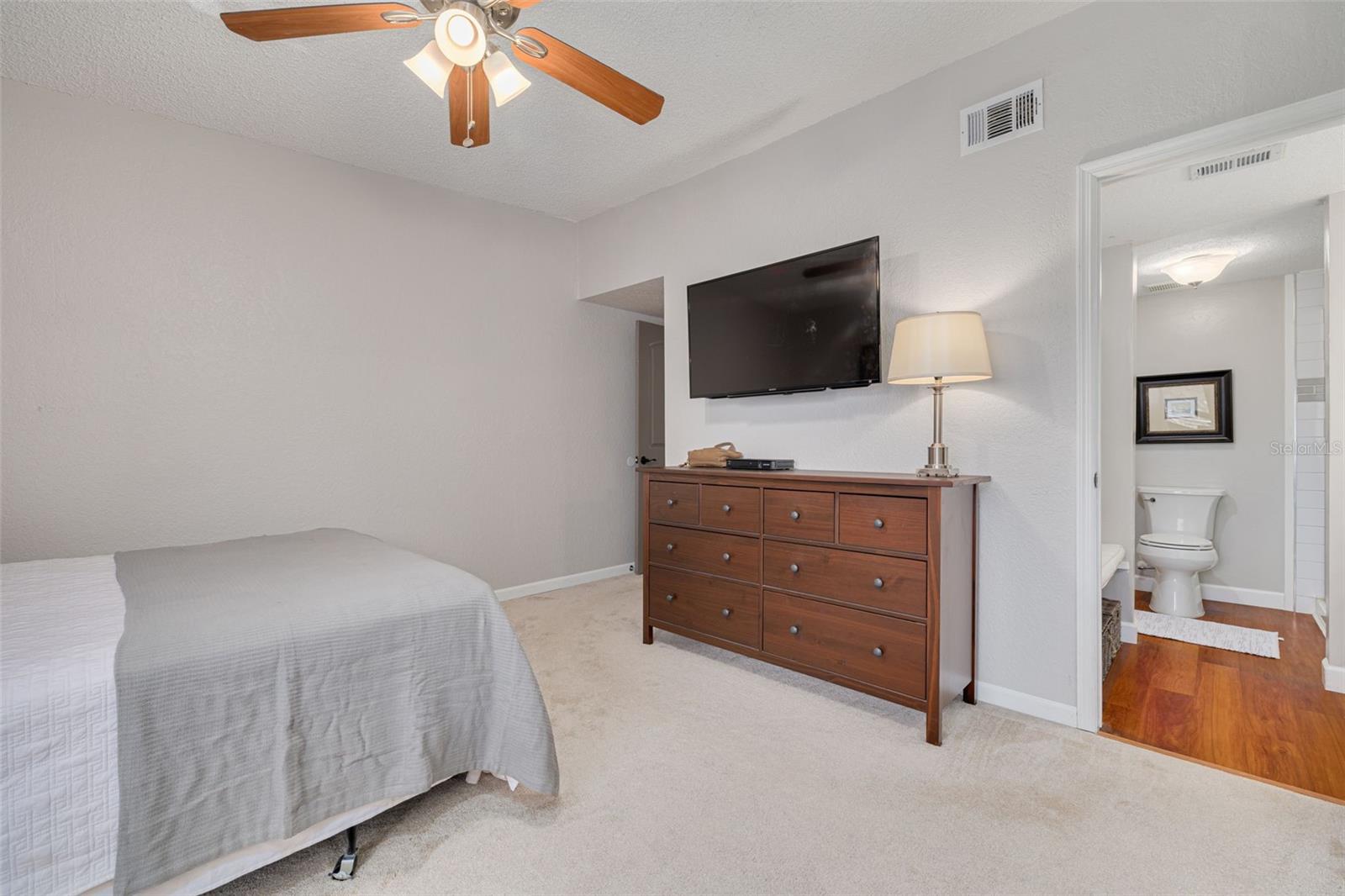 Primary Bedroom with ceiling fan and high ceiling.