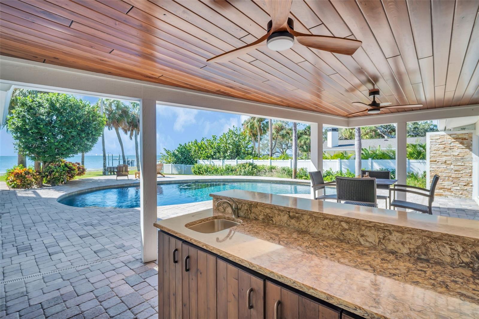 Covered patio, bar area and pass through with wood finished ceiling treatments