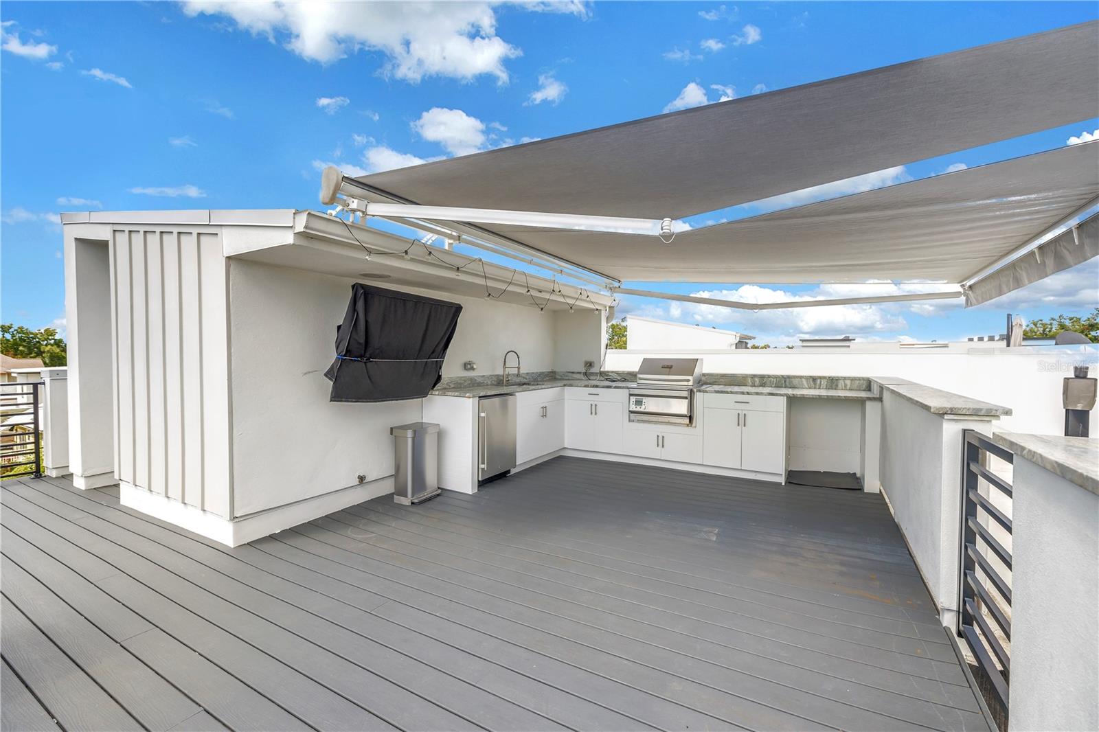 Electric awning provides ample shade for outdoor kitchen.