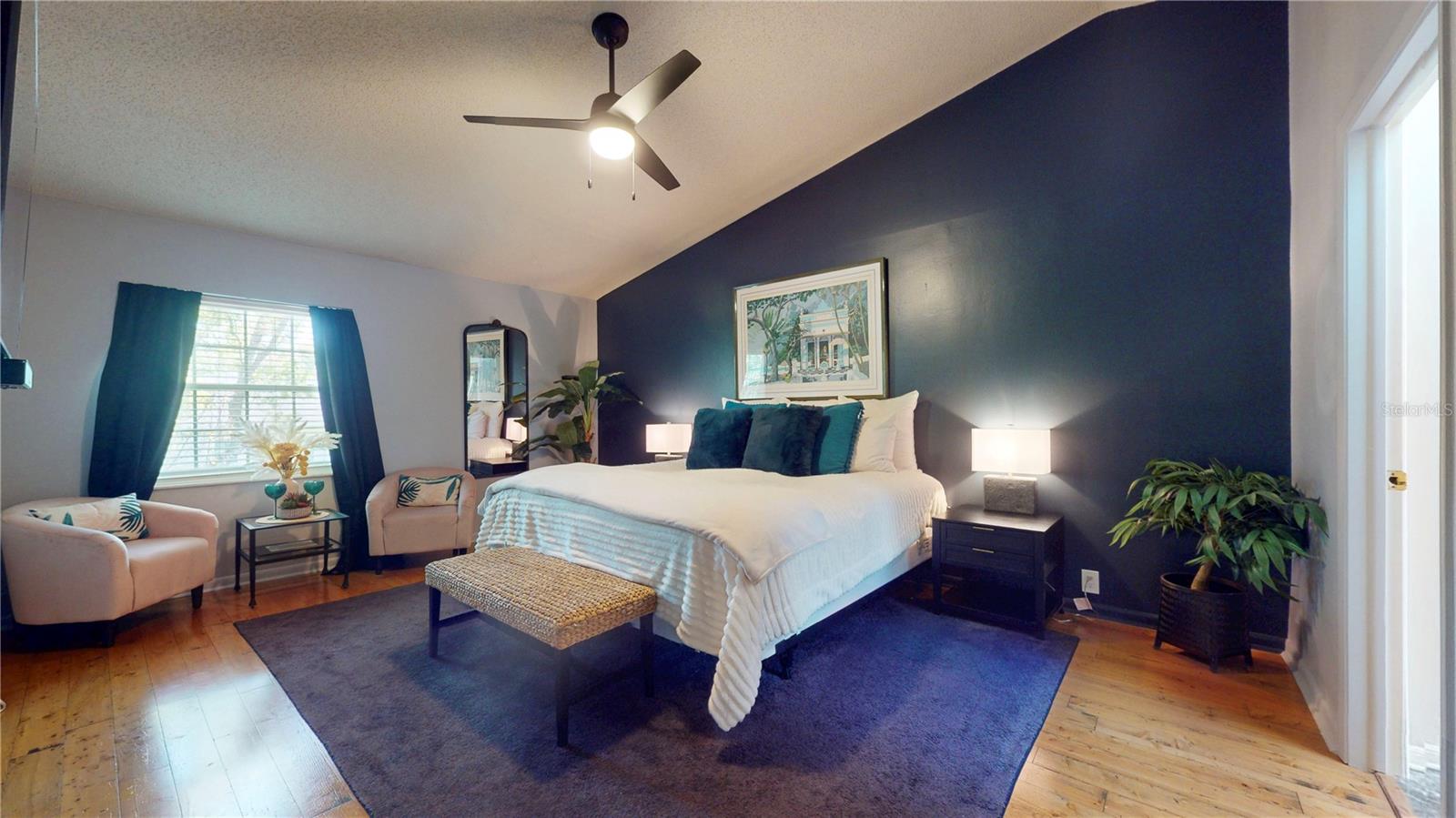 Primary bedroom with sitting area, high ceilings, lots of natural light during the day, and ensuite bath.