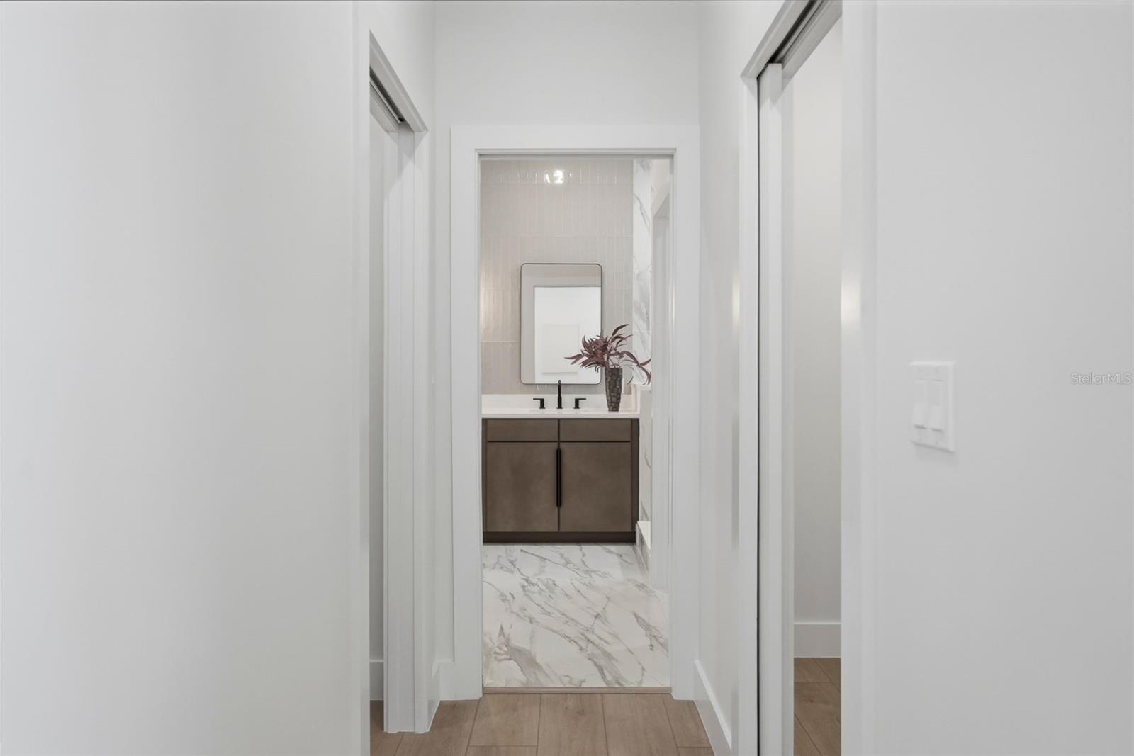 dual primary walk in closets in hallway towards primary bath