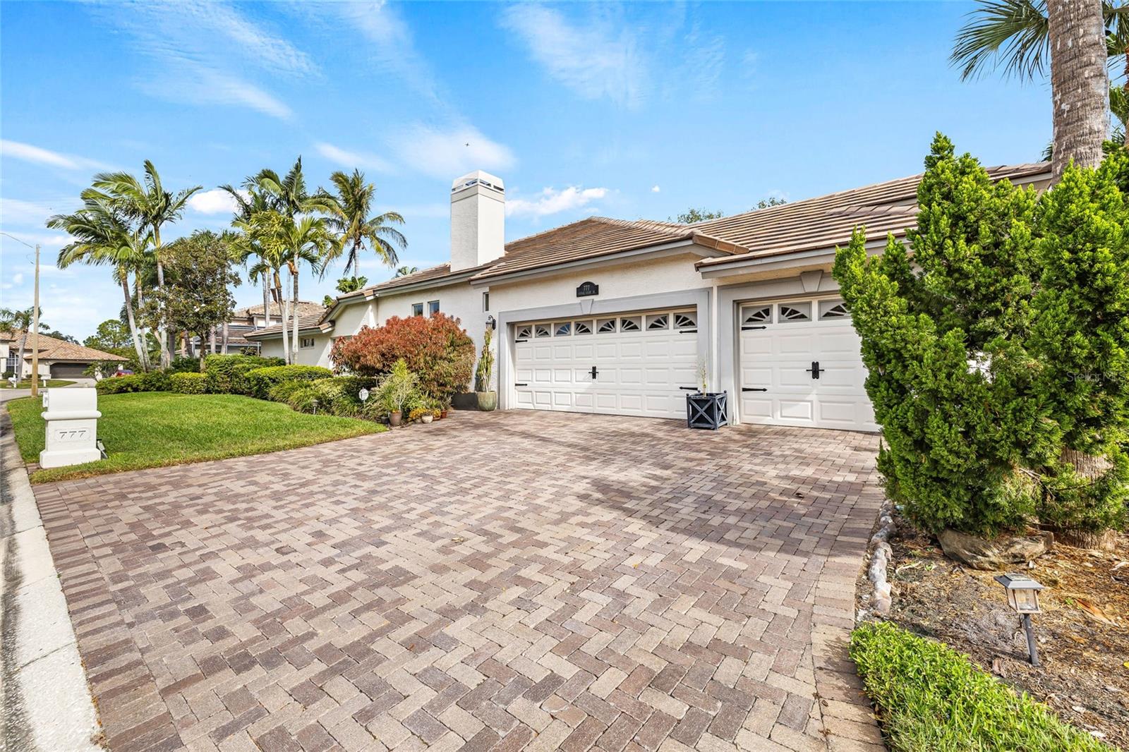 Three car garage with side entrance and artisan pavers.