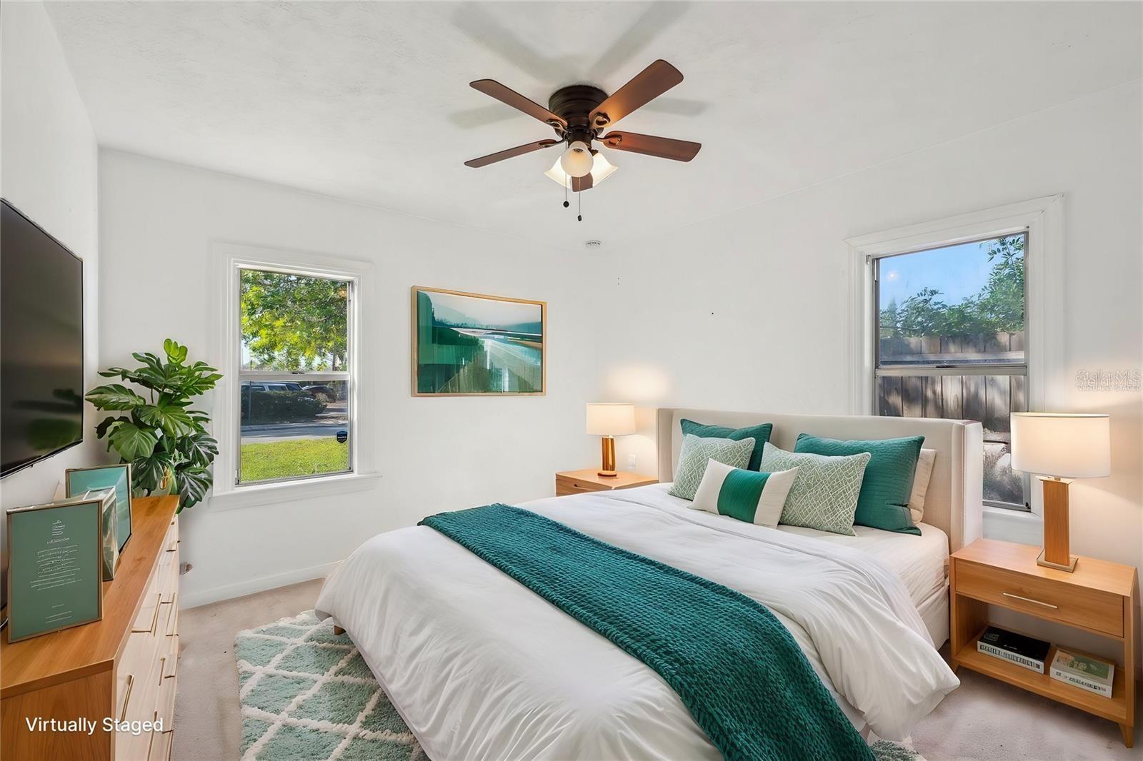 Bright primary bedroom featuring generous windows, and serene views.