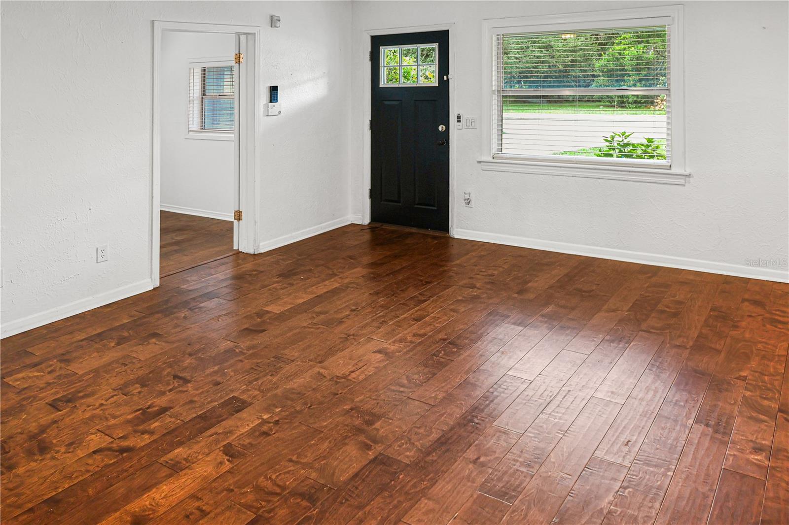 Cozy living room with warm wood floors and a welcoming entryway.