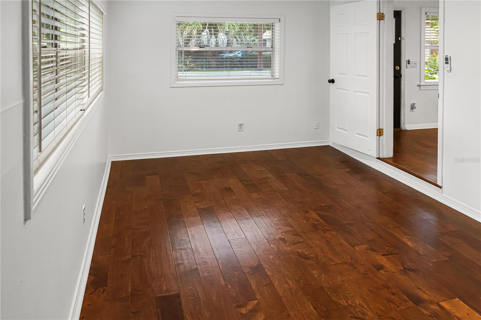 Stylish flex room with rich wood floors, perfect for a dedicated home office, gym, or hobby space.