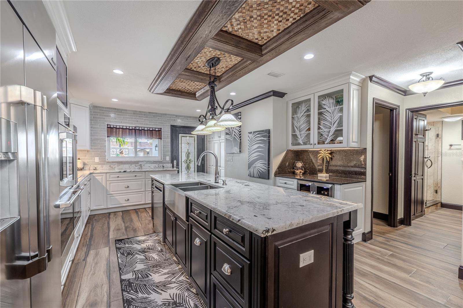 The open dining area creates a warm connection between the kitchen and living spaces, framed by water views and crown-molded ceilings.